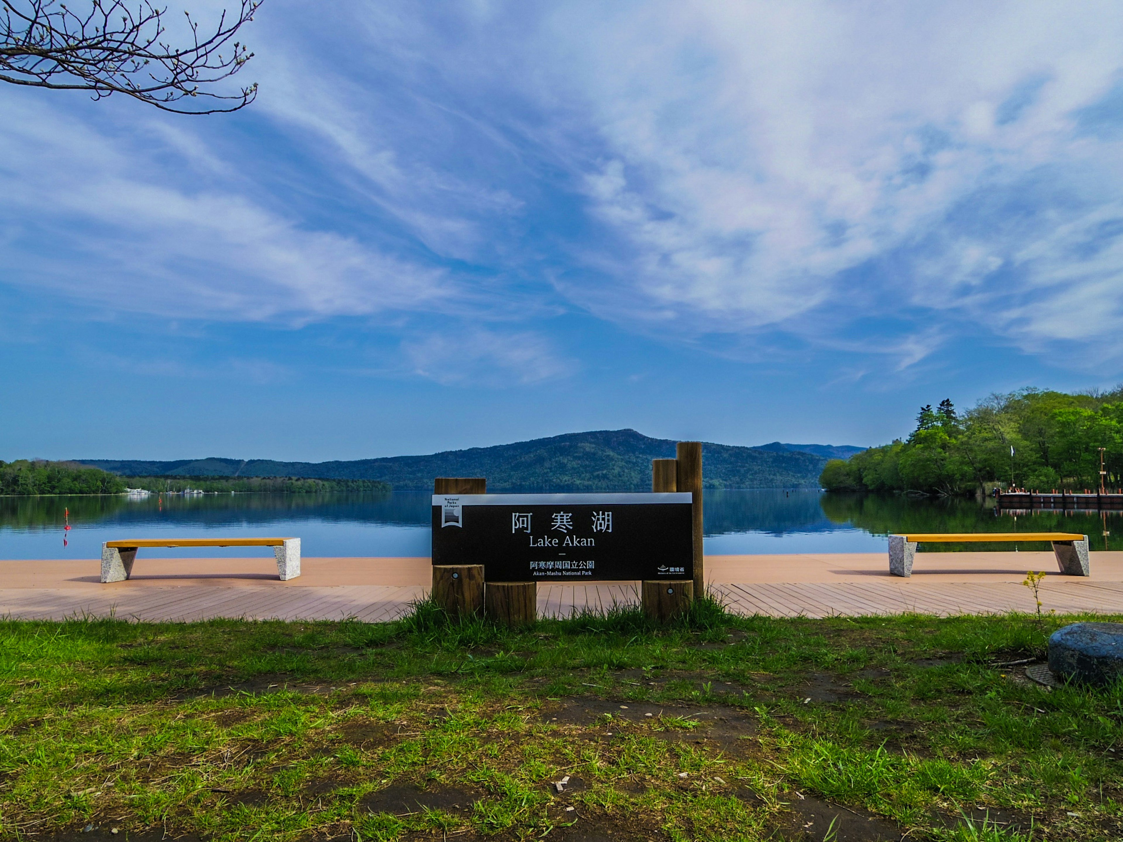 Vista escénica de un lago con bancos y cielo azul