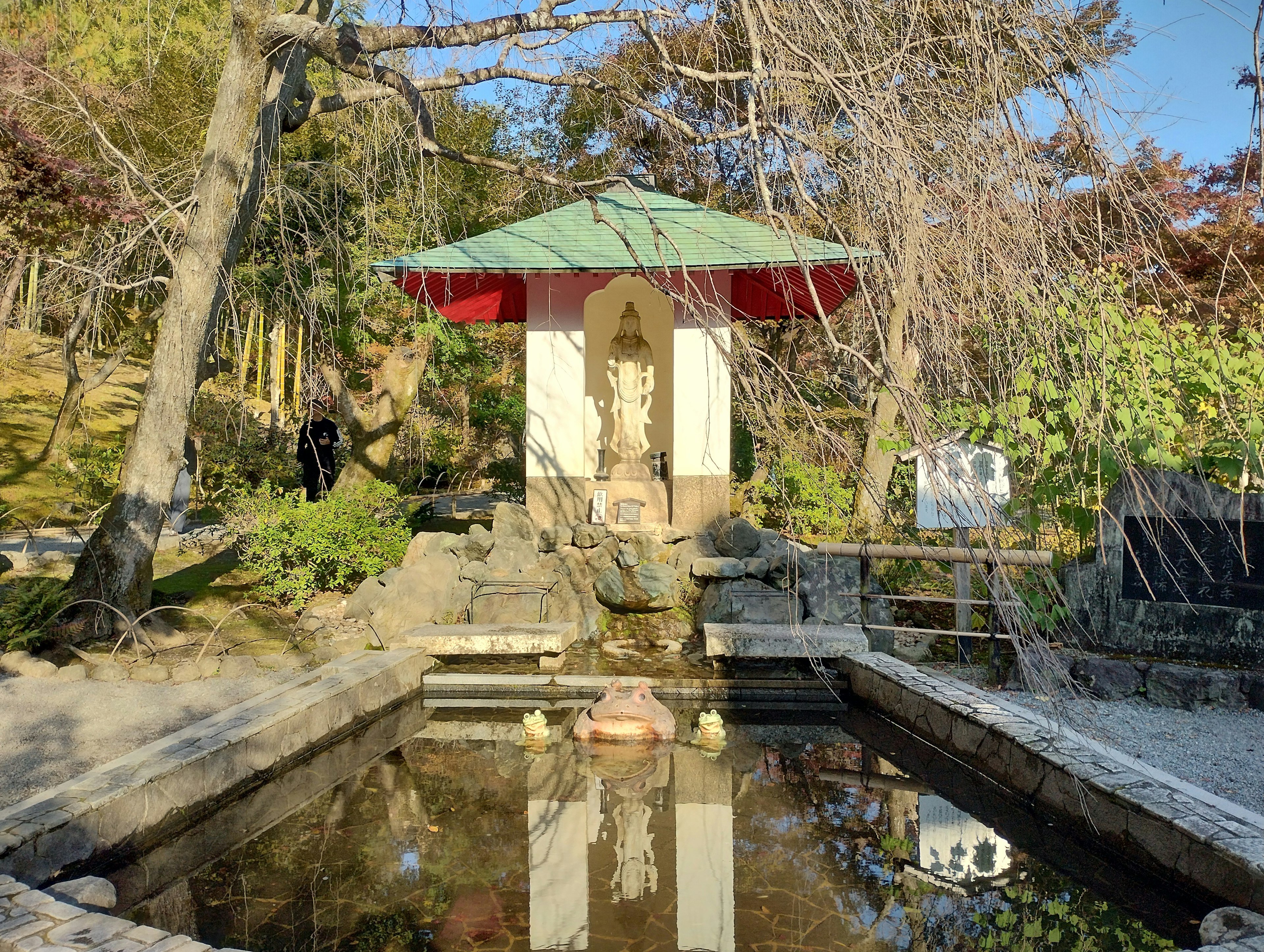 Serene garden scene featuring a small shrine and pond