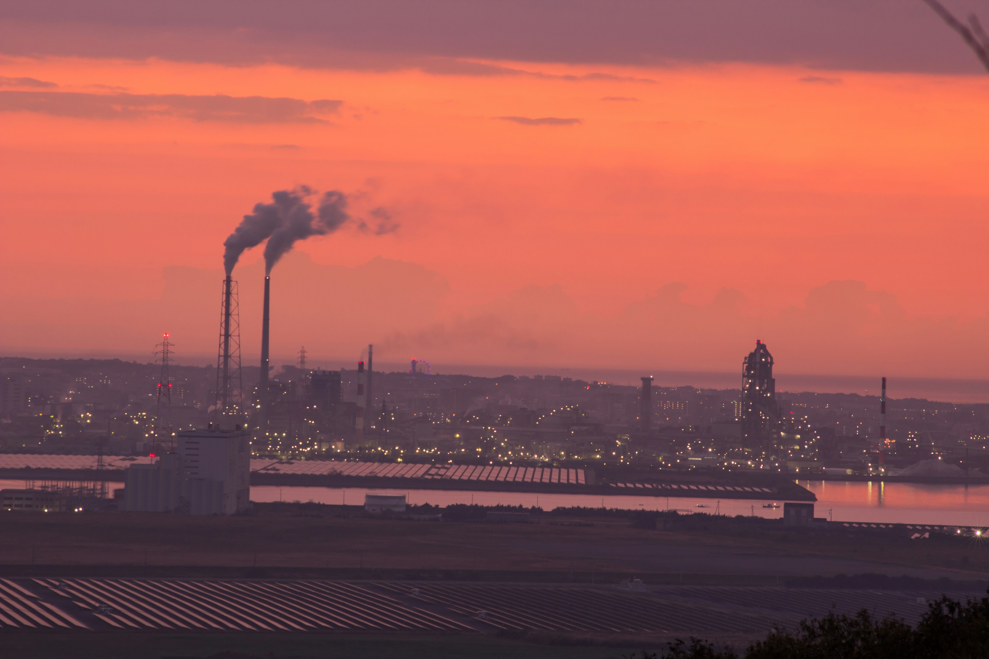 Orizzonte industriale con camini contro un vivace tramonto