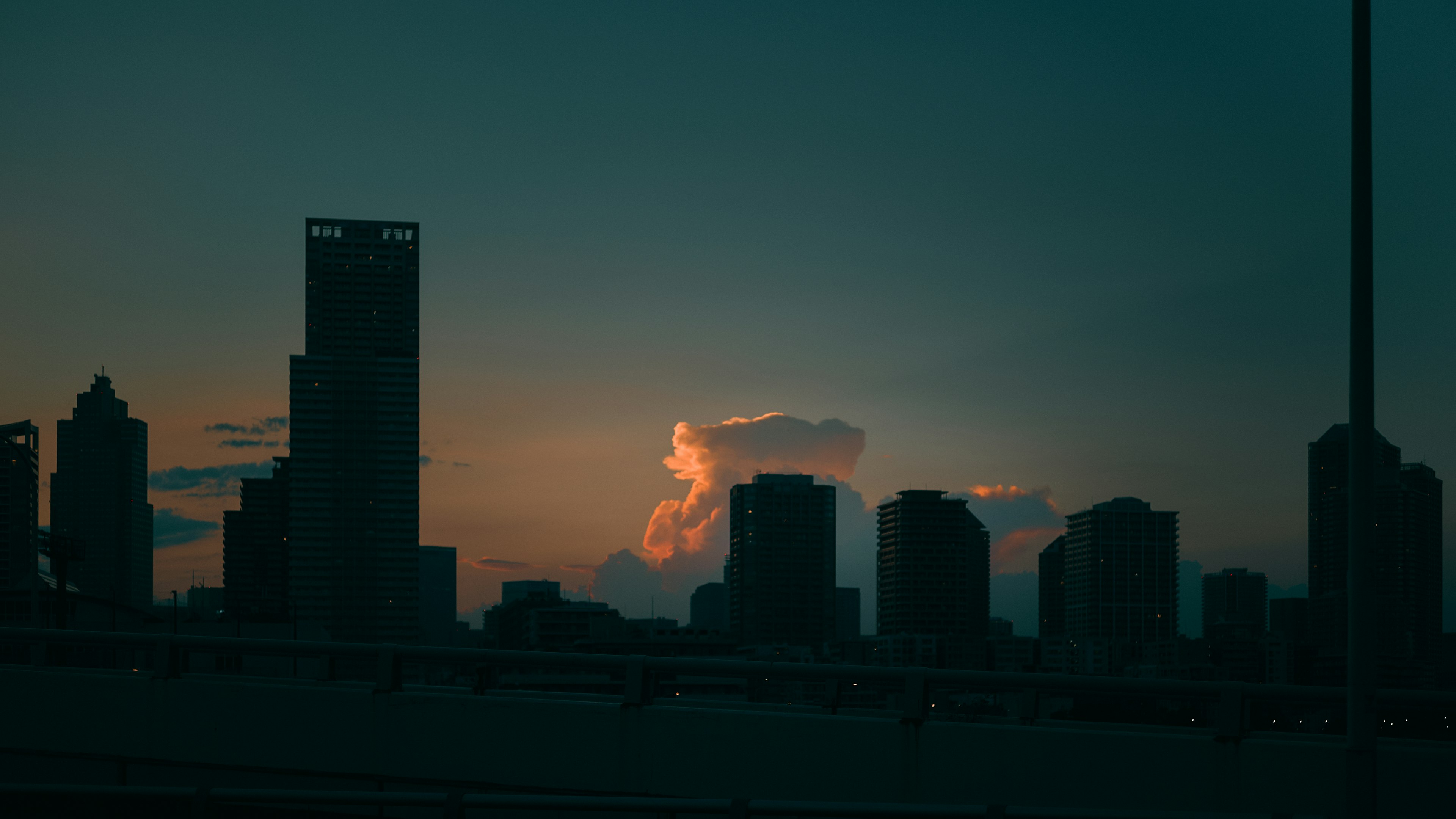 City skyline silhouette at sunset with orange clouds