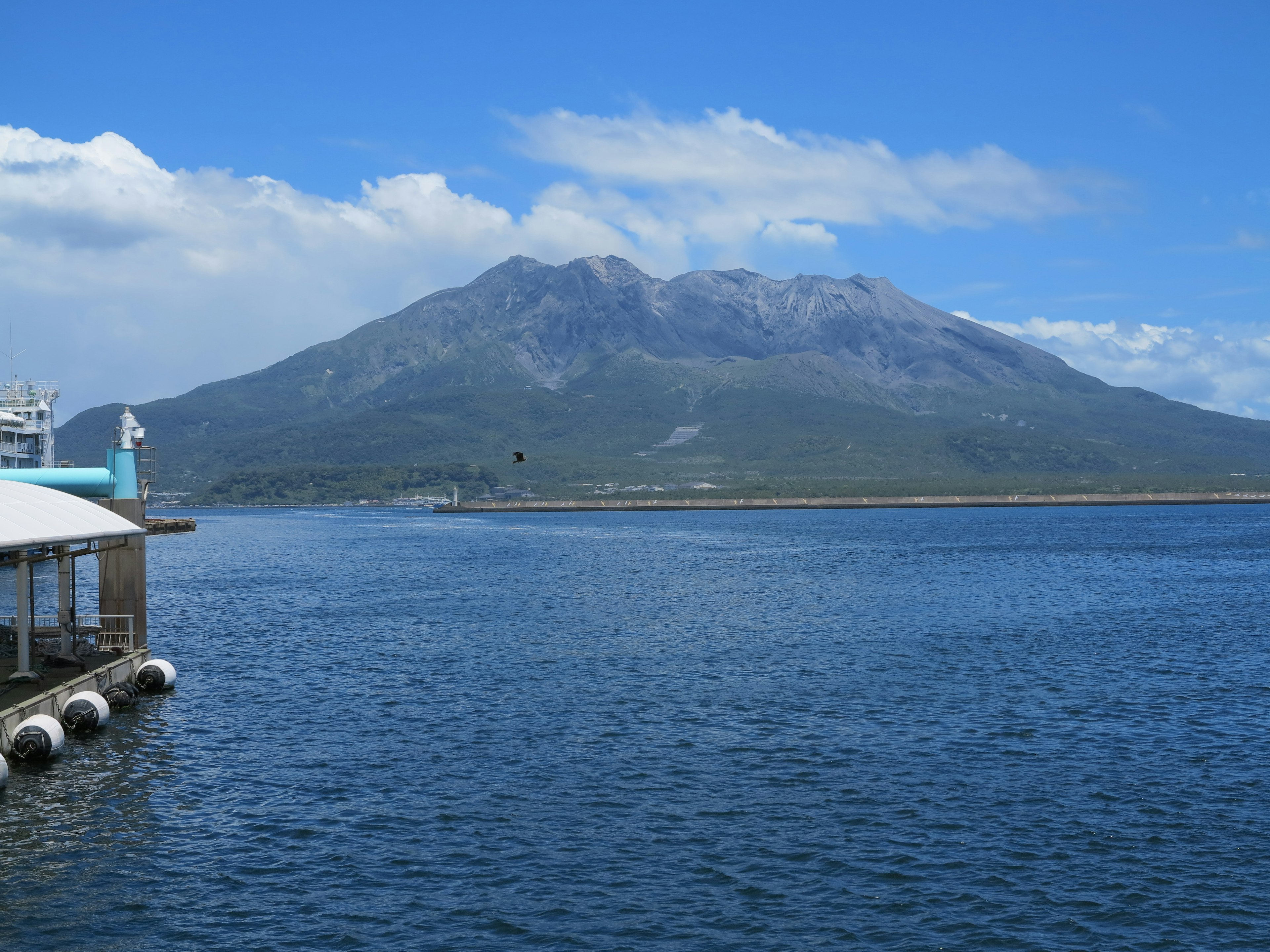 青い空と雲の下にそびえる山と水面