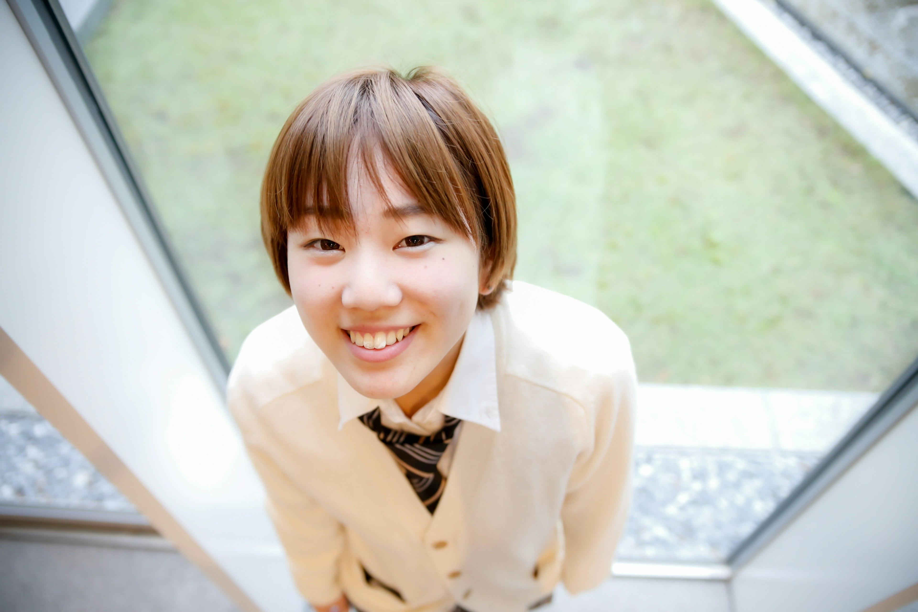 Young woman smiling and looking up at the camera in an indoor setting