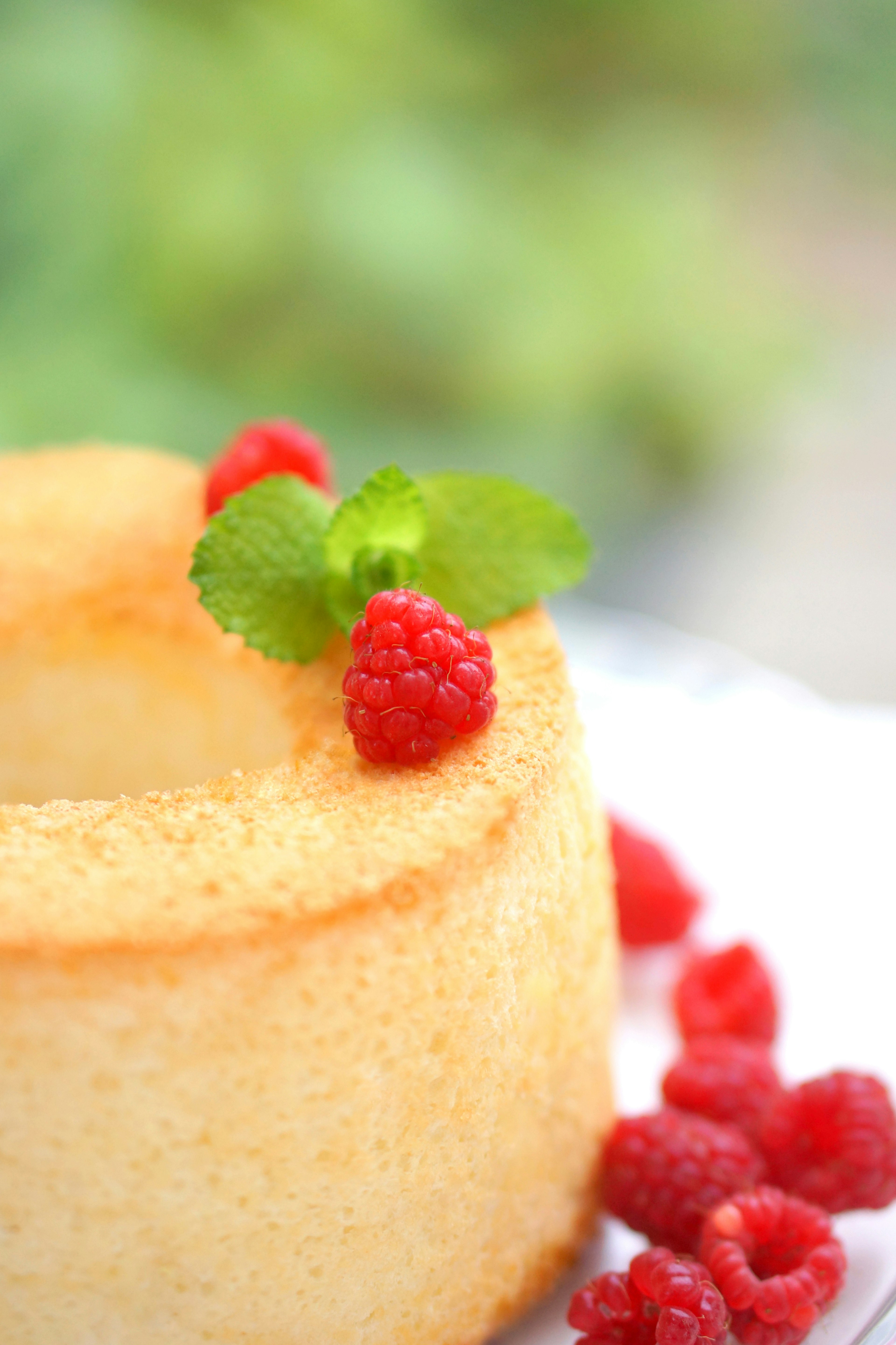 Fluffiger Biskuitkuchen mit Himbeeren und Minzblättern dekoriert