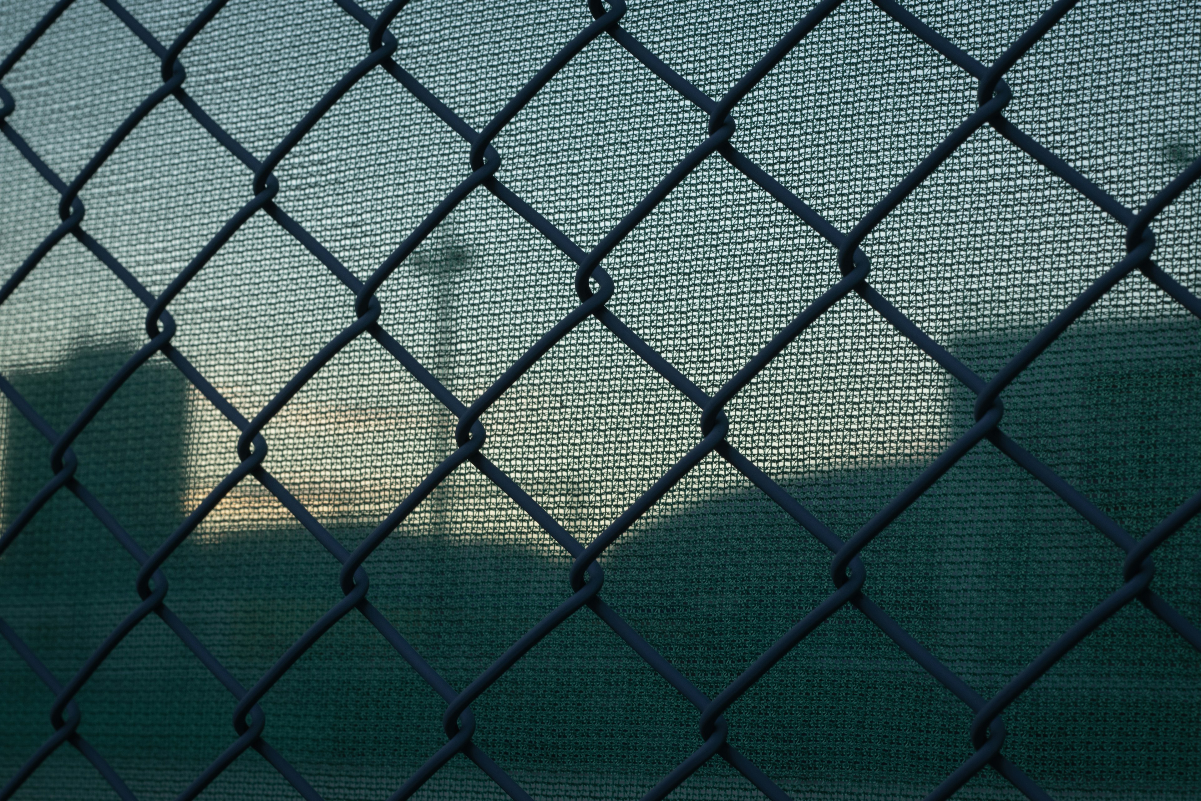 Vista de un atardecer a través de una cerca de cadena