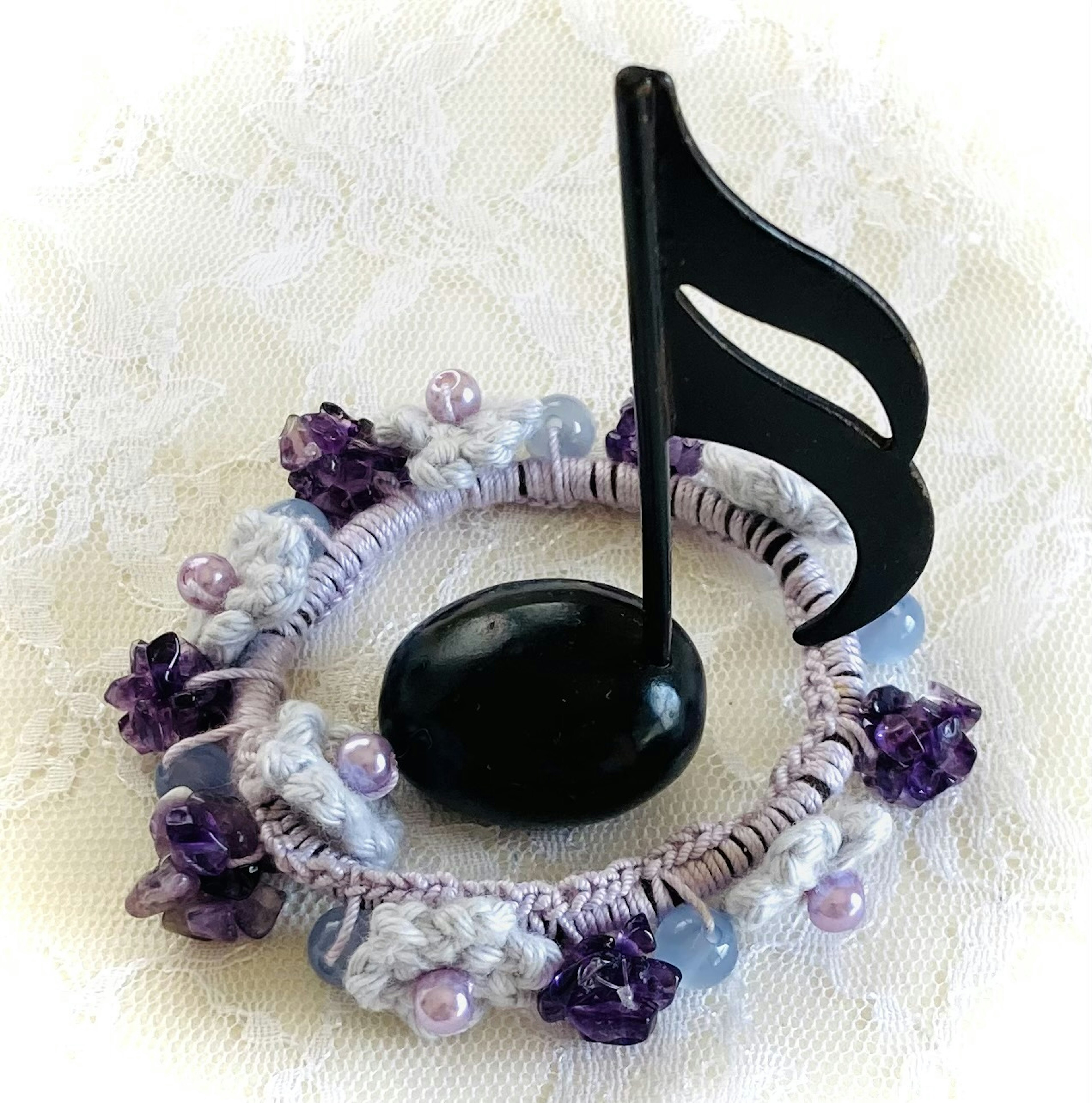 Musical note stand adorned with purple beads and flowers