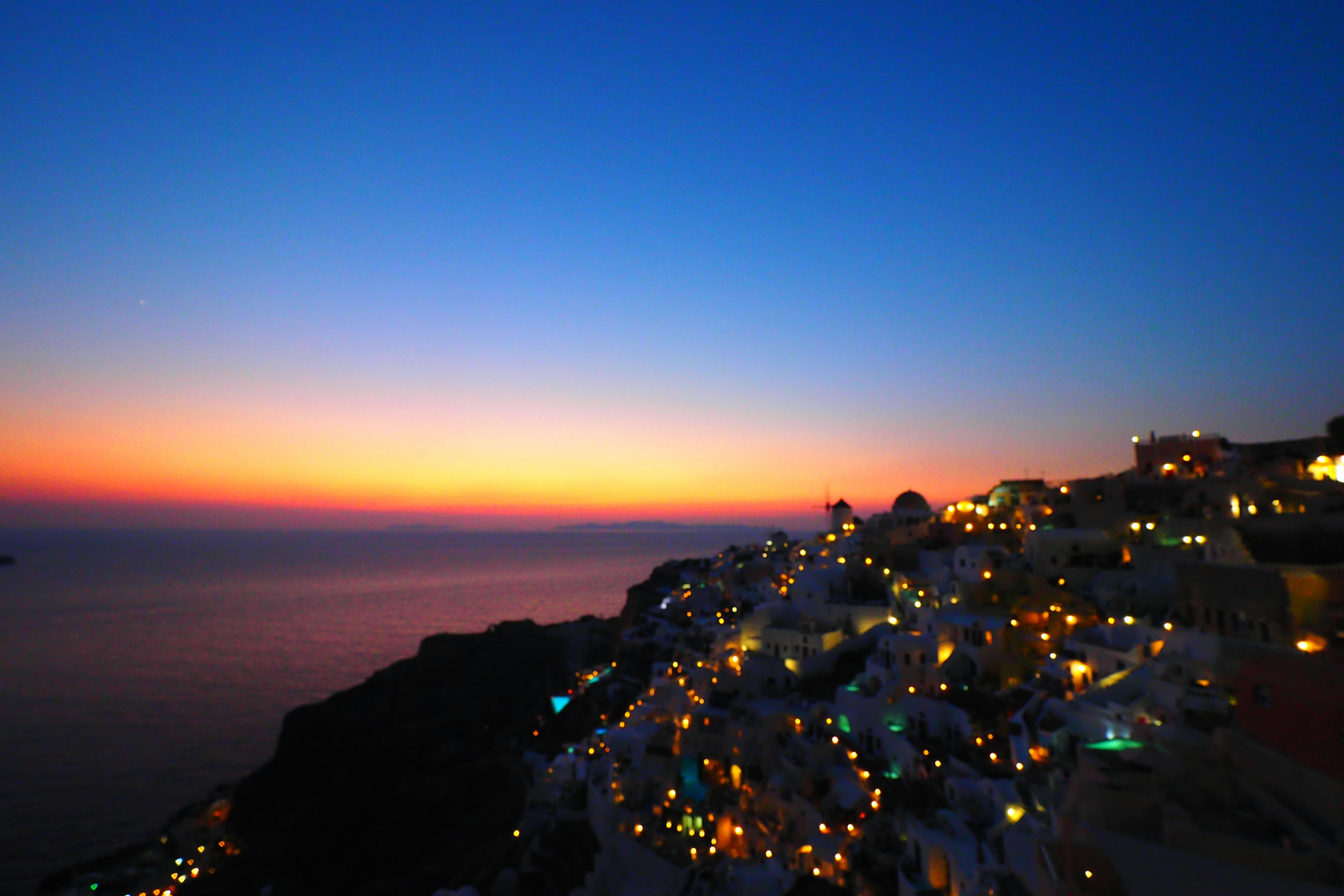 Stupenda vista del tramonto di Santorini con edifici illuminati