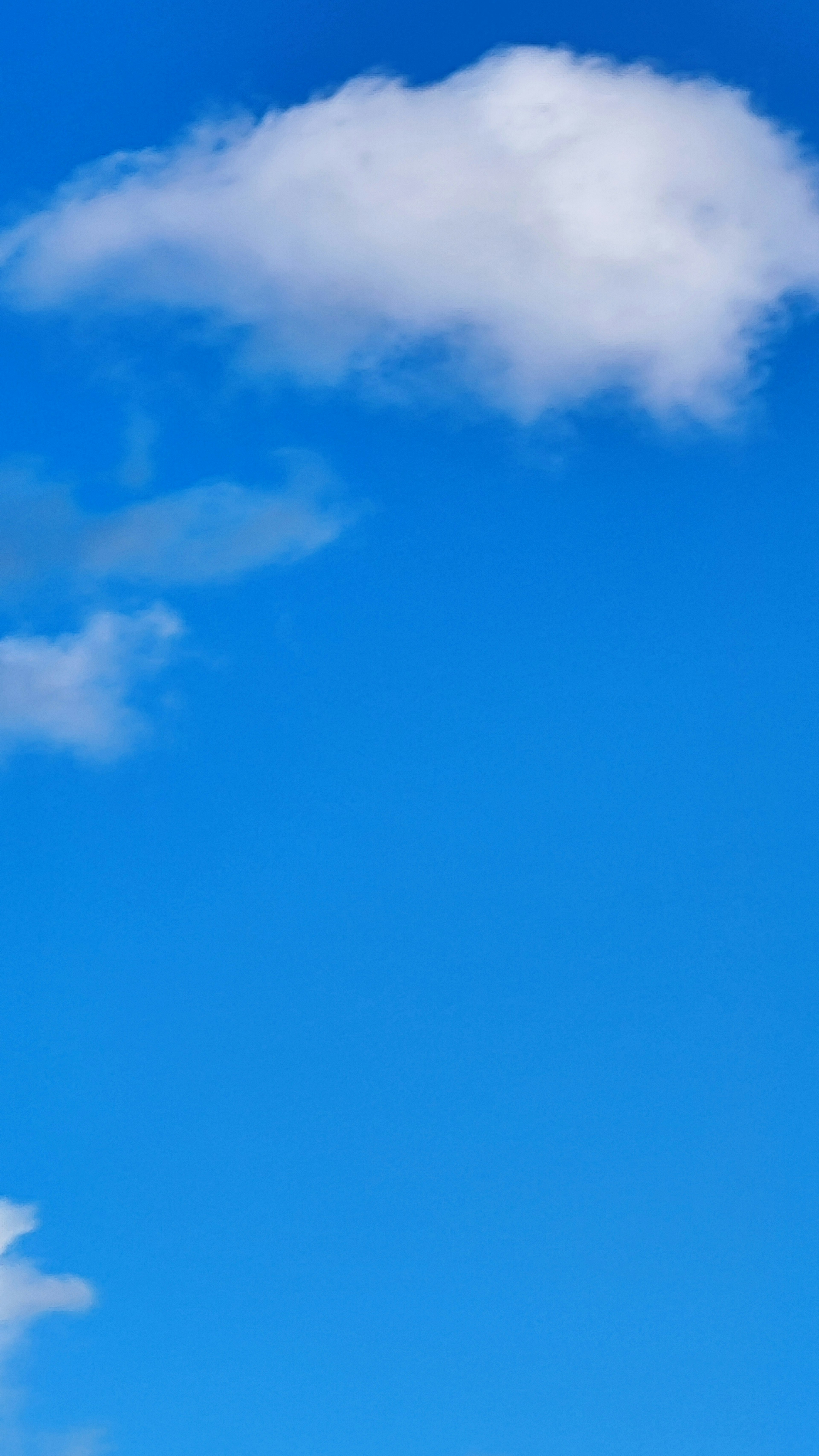 Einfache Ansicht von weißen Wolken, die in einem blauen Himmel schweben