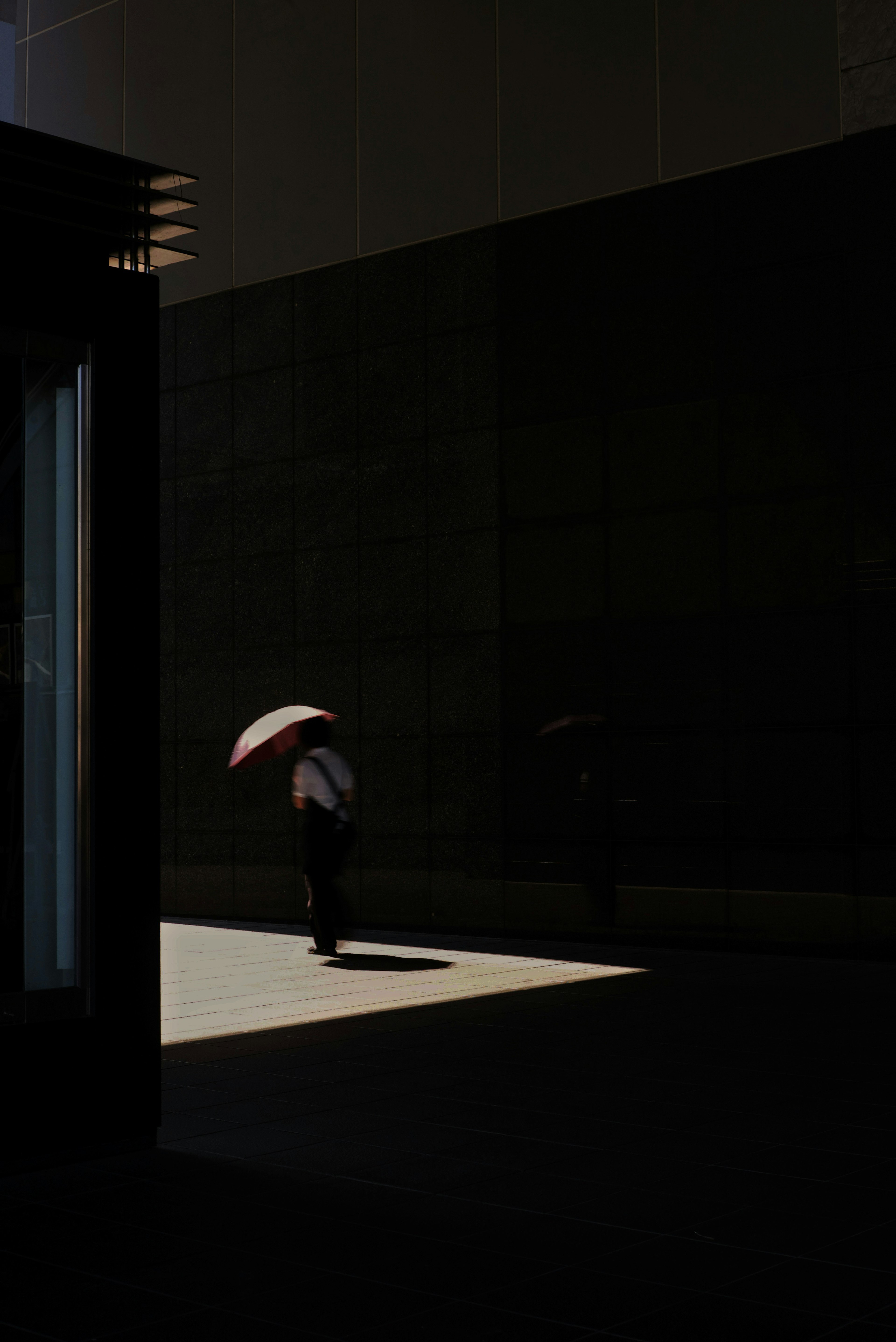 Silhouette di una persona con un ombrello su sfondo scuro