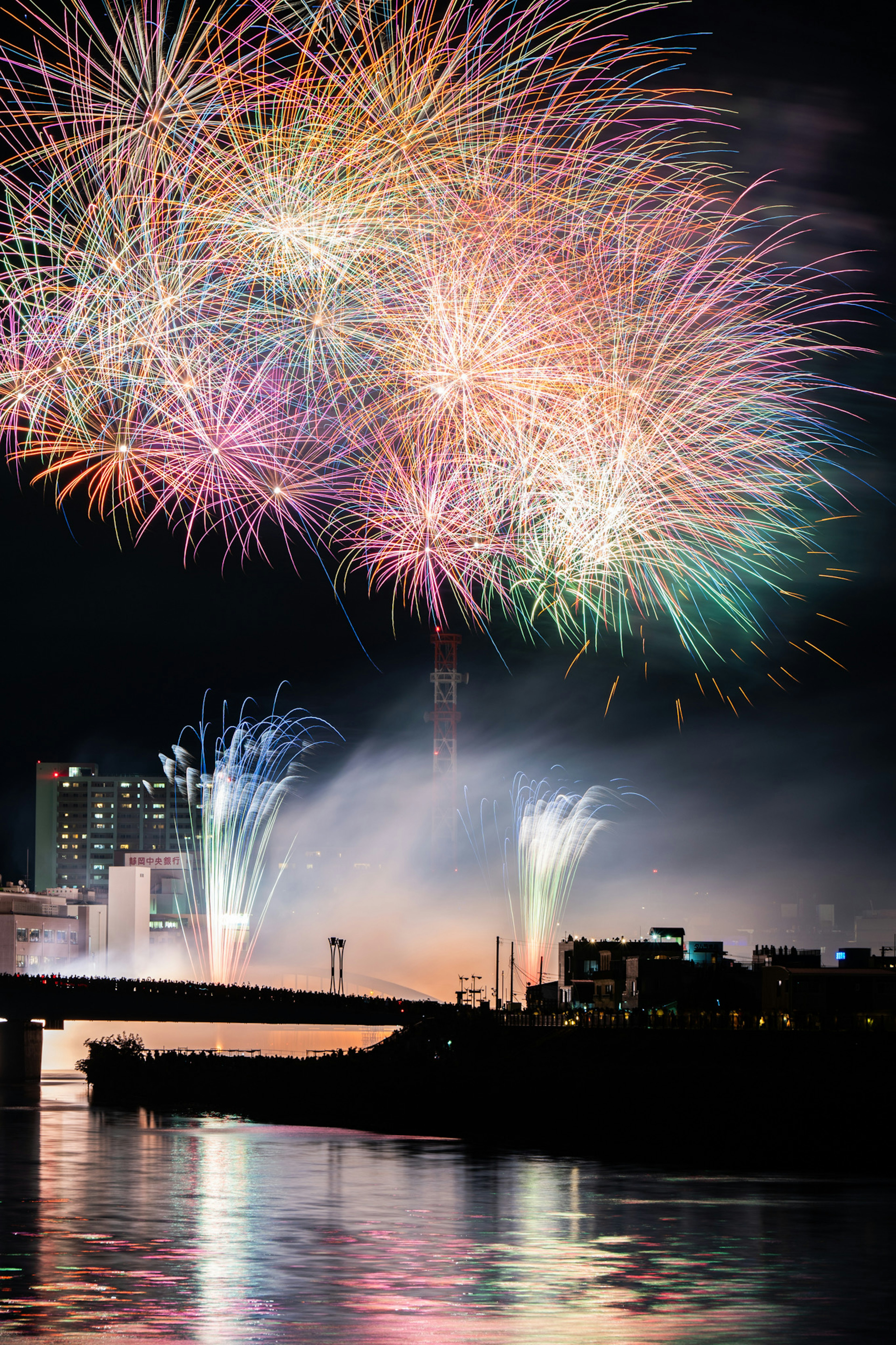 夜空中綻放的五彩煙花在水面上反射