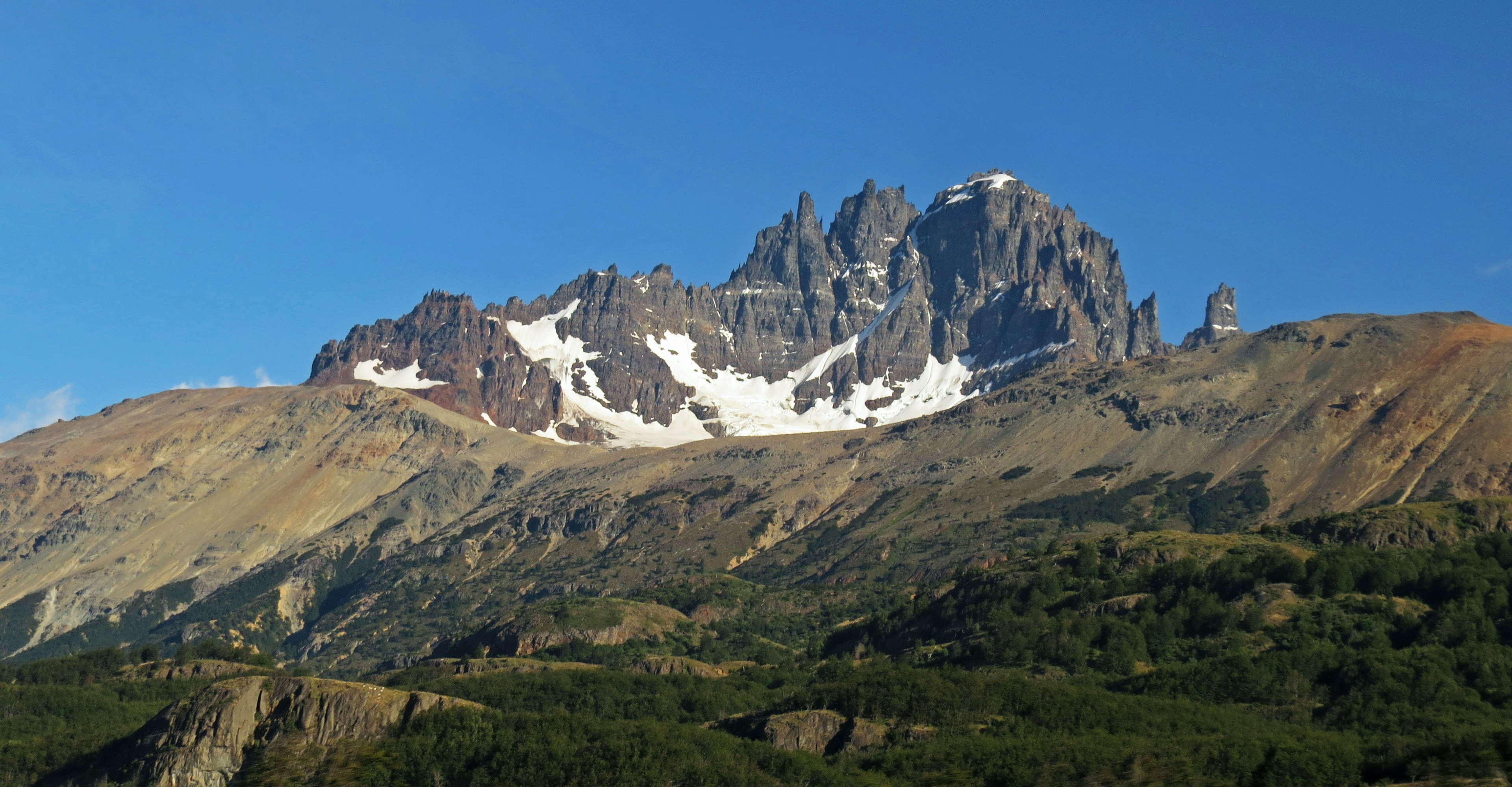 Stunning mountain landscape featuring snow-capped peaks and a clear blue sky