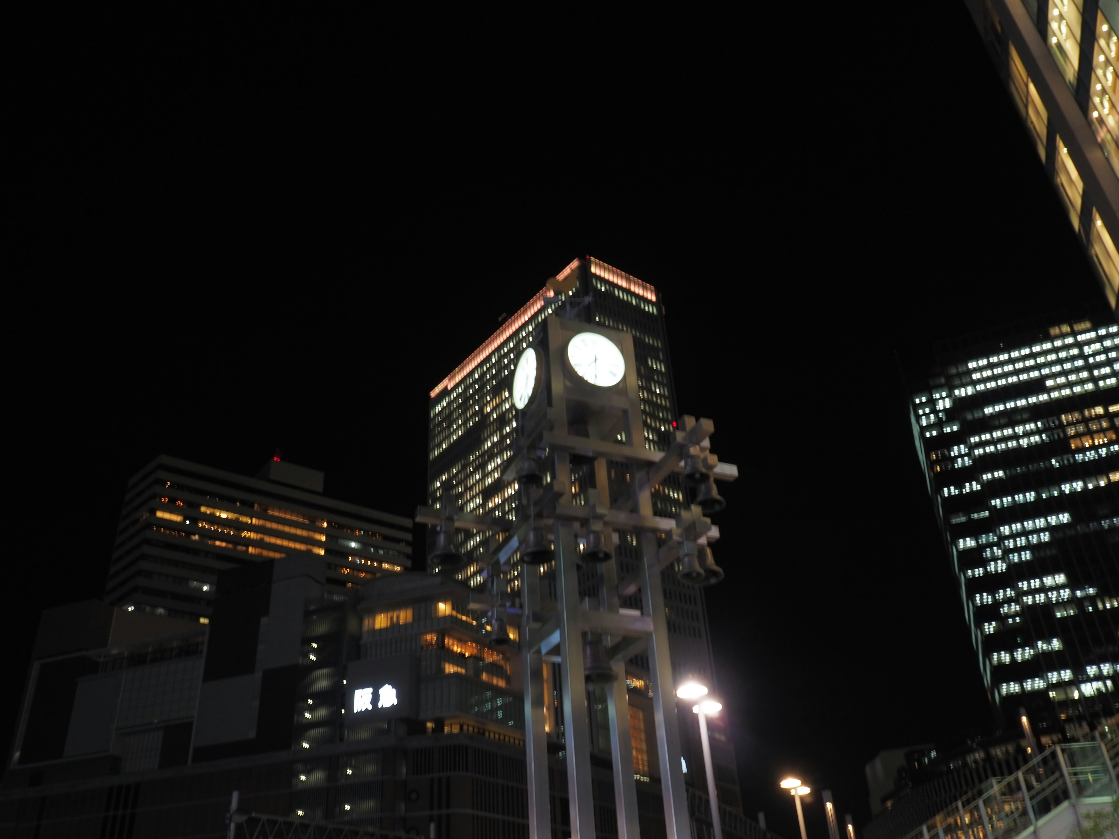 Illuminated clock tower and skyscrapers at night