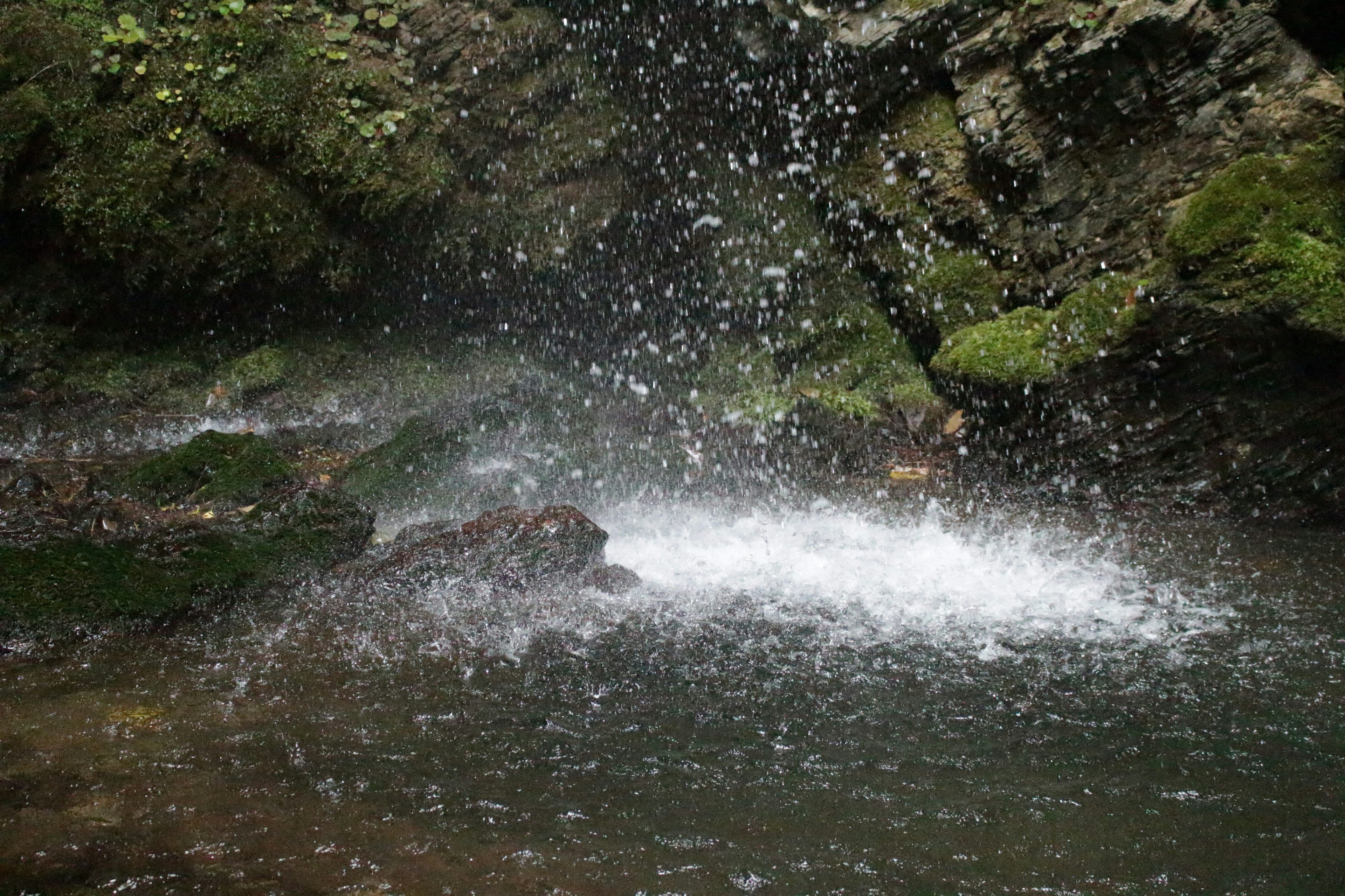 Malersiche Aussicht auf einen felsigen Bereich in der Nähe eines Wasserfalls mit spritzendem Wasser