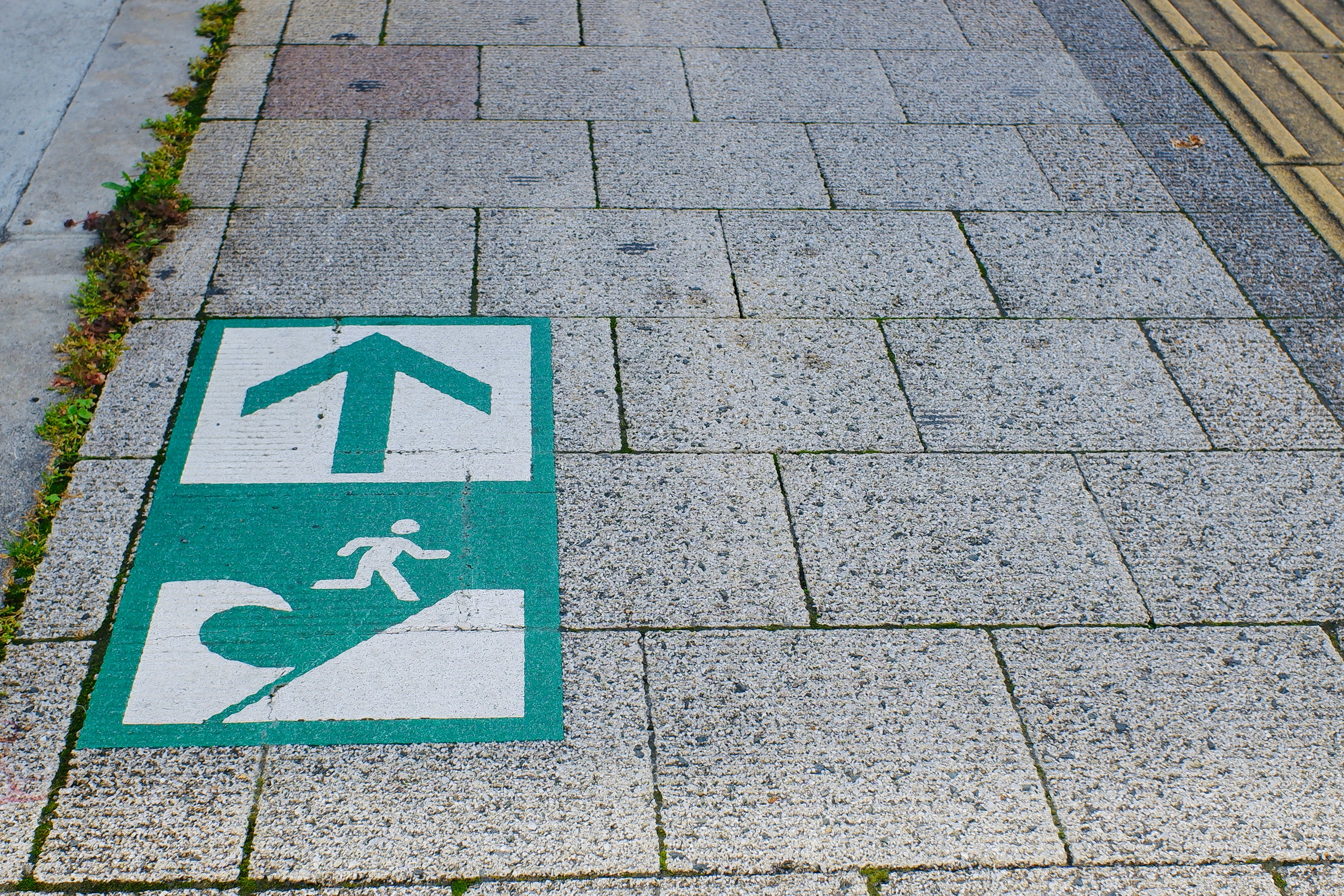 Marquages sur le trottoir avec une flèche vers le haut et un symbole de vague