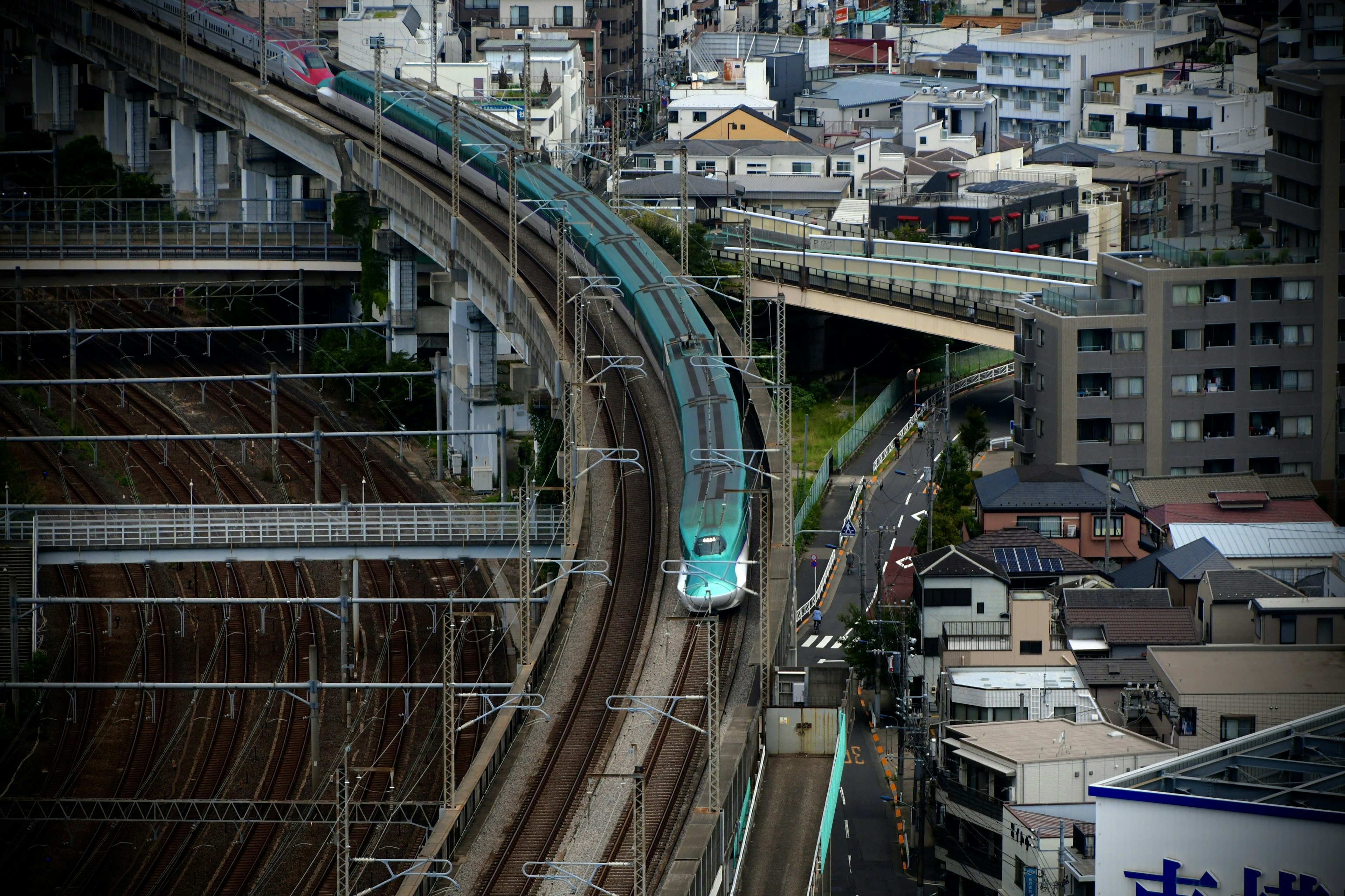 Lignes de train courbes avec un train dans un paysage urbain