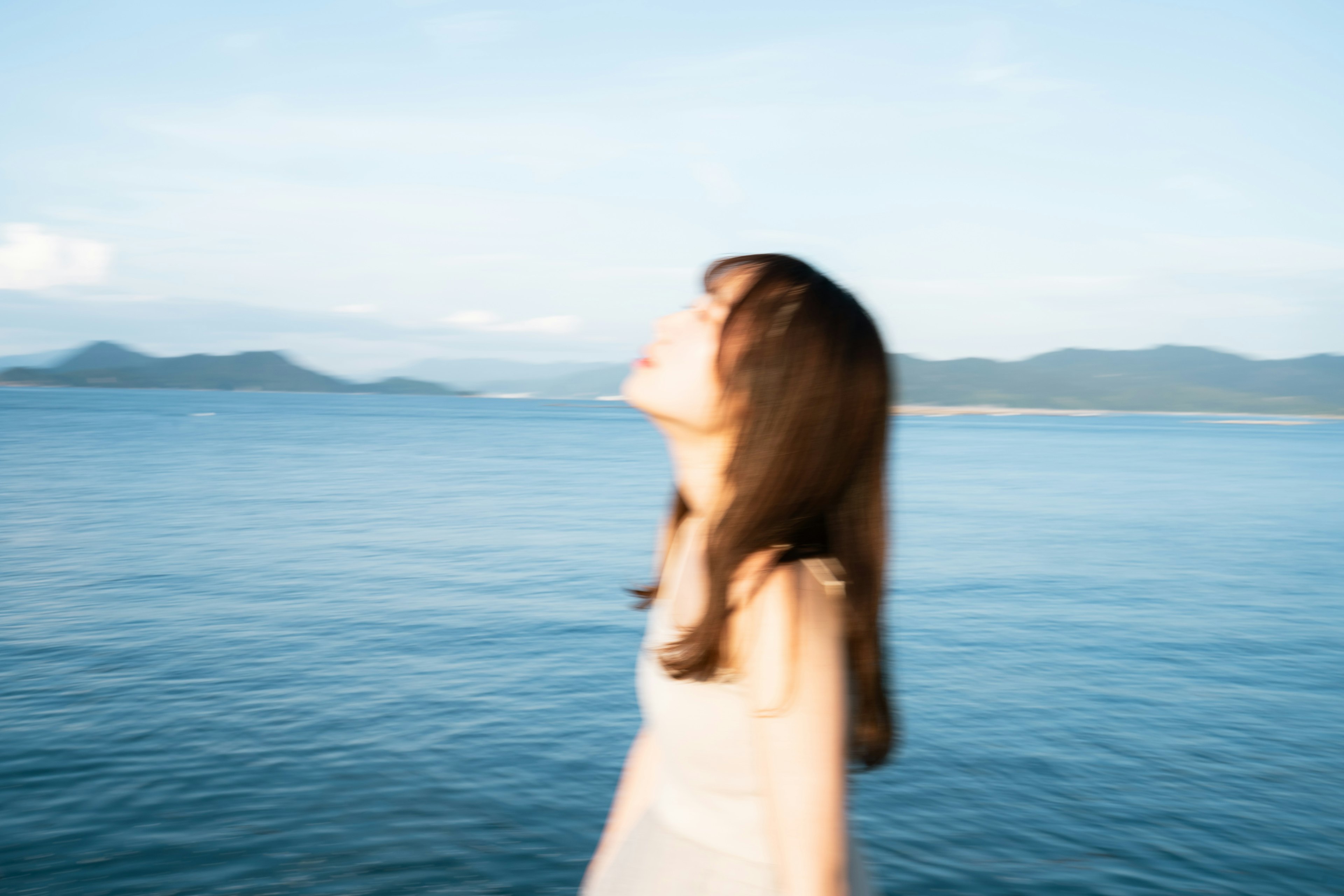 海辺で空を見上げる女性の姿