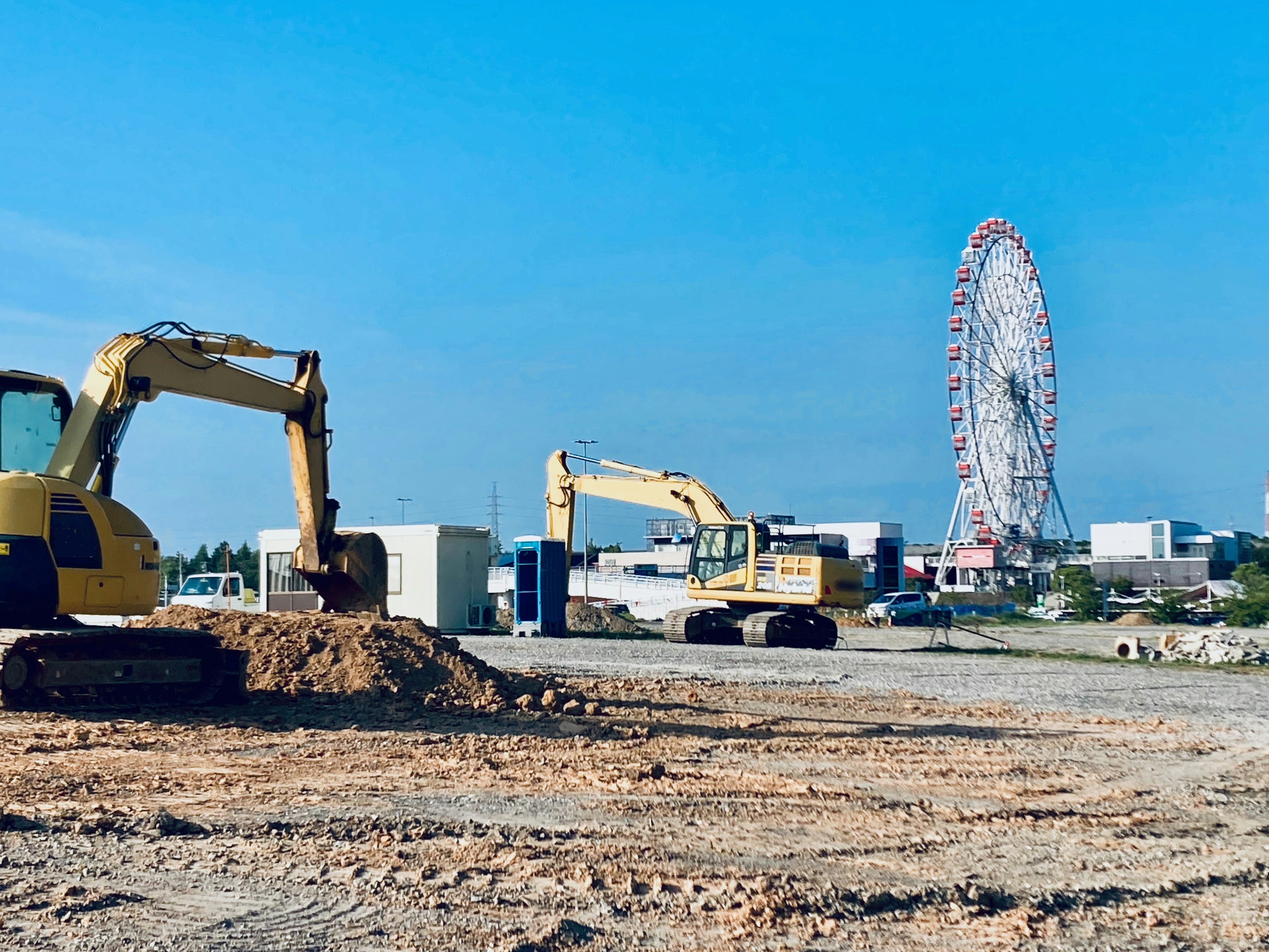 Construction site featuring excavators and a ferris wheel