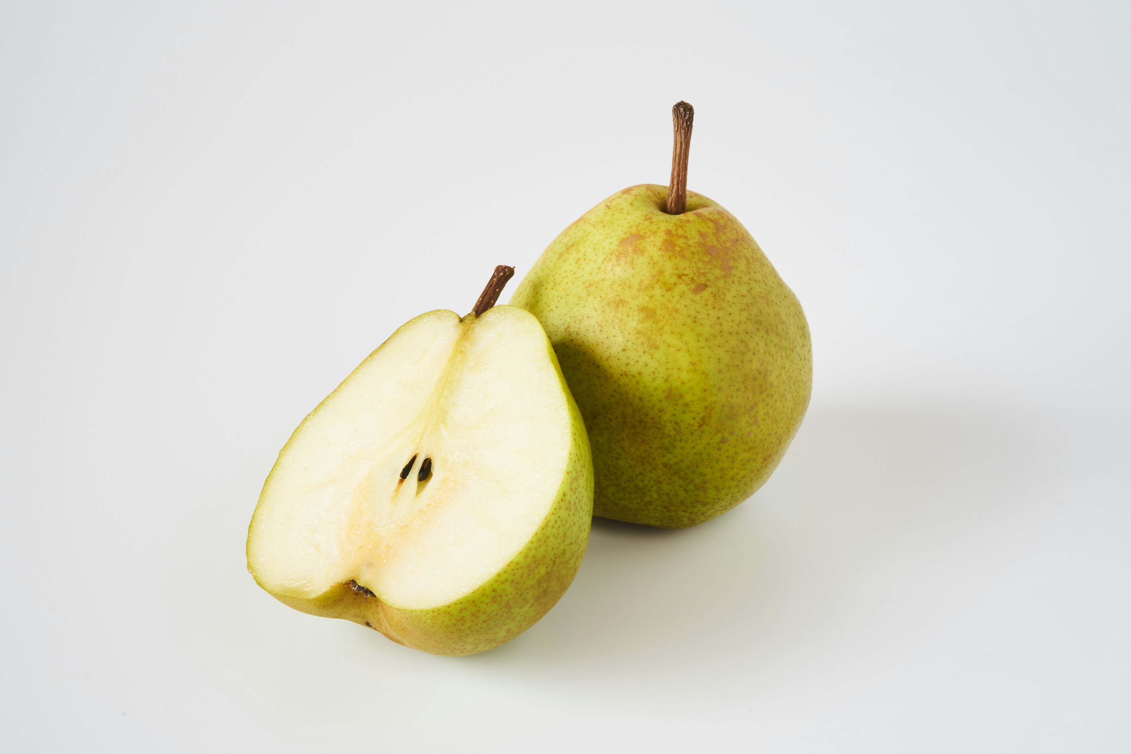 Green pear with a sliced half showing inside