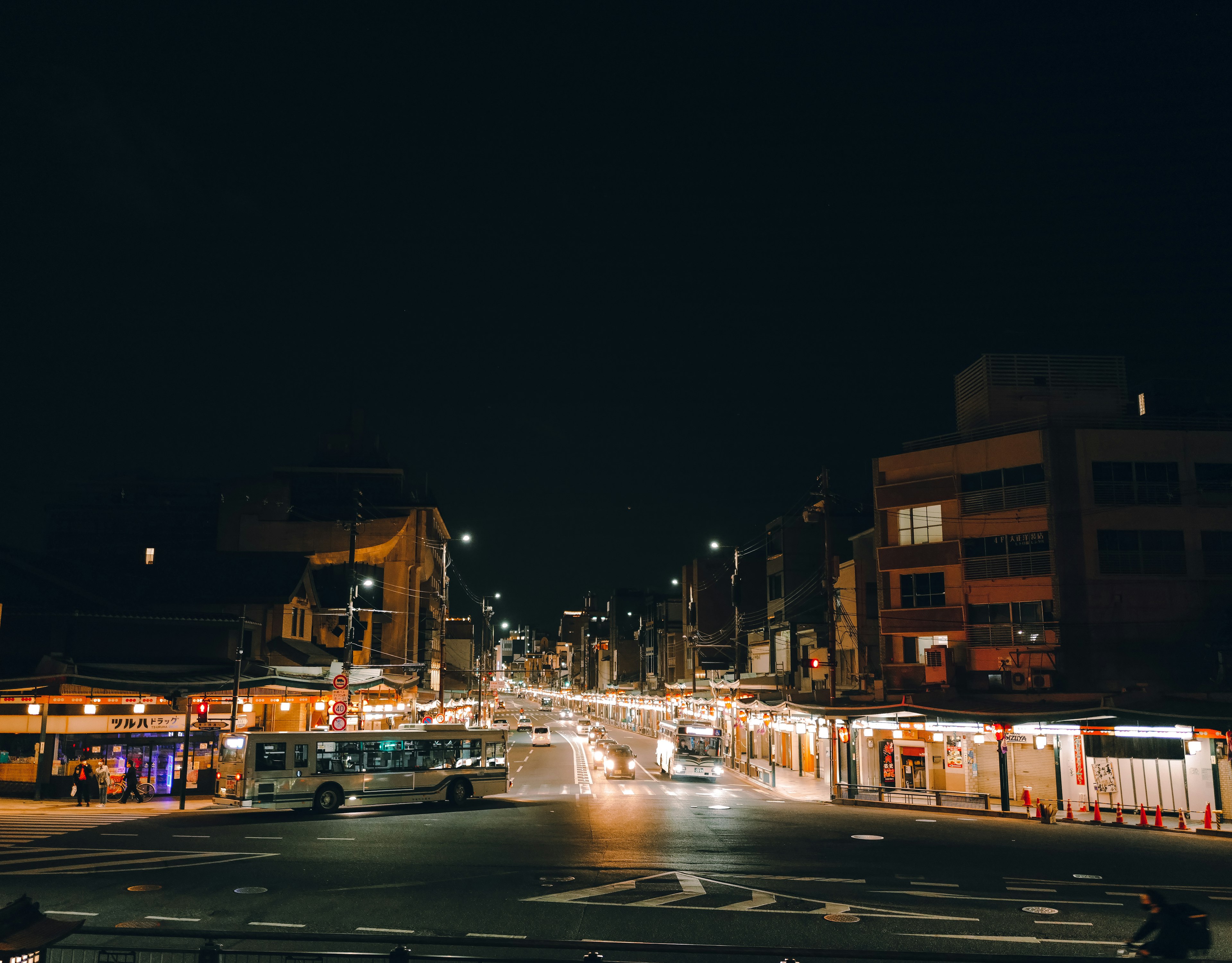 Vue nocturne d'une rue avec des bâtiments illuminés et du trafic