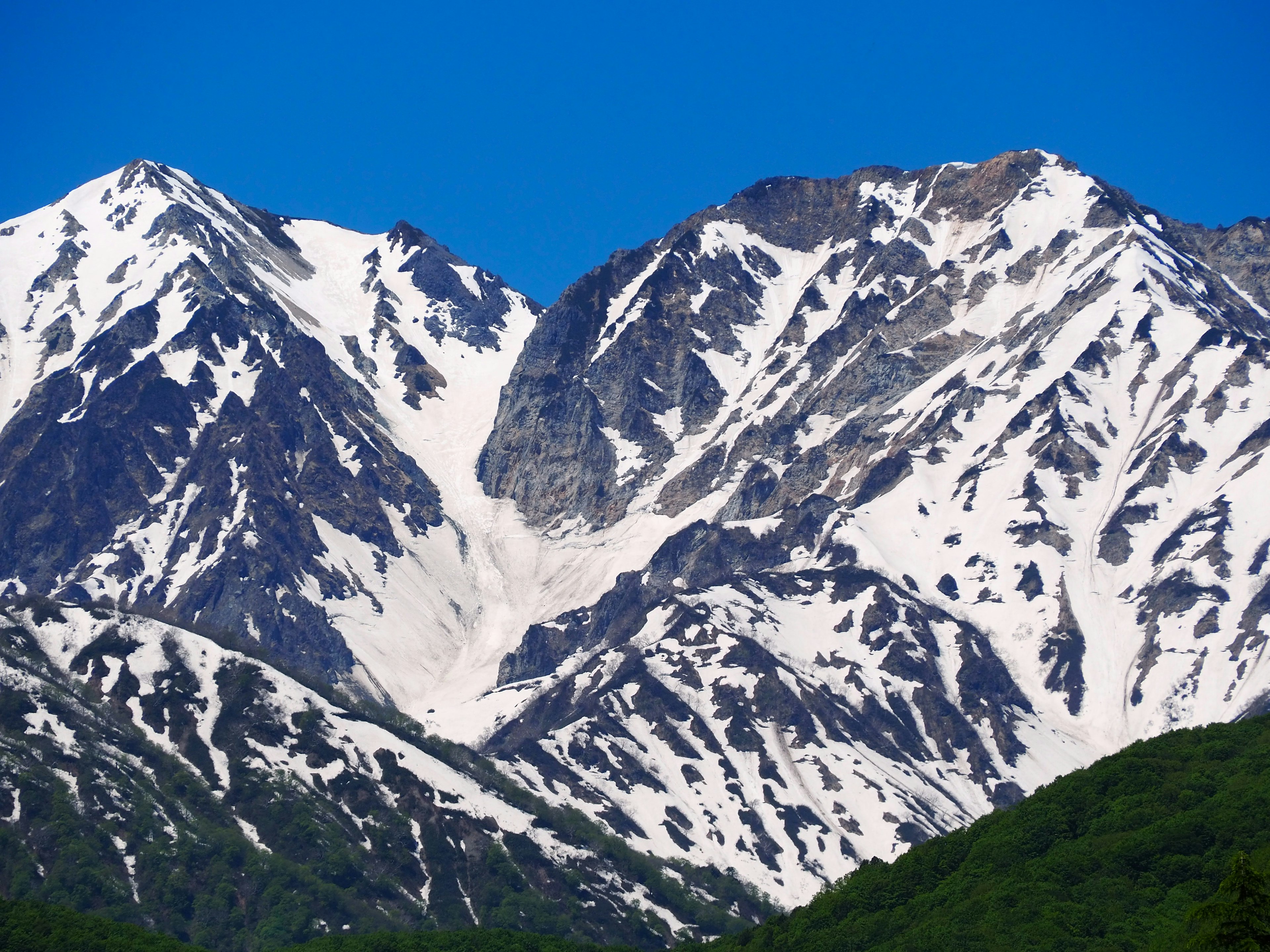 Gunung bersalju yang megah di bawah langit biru