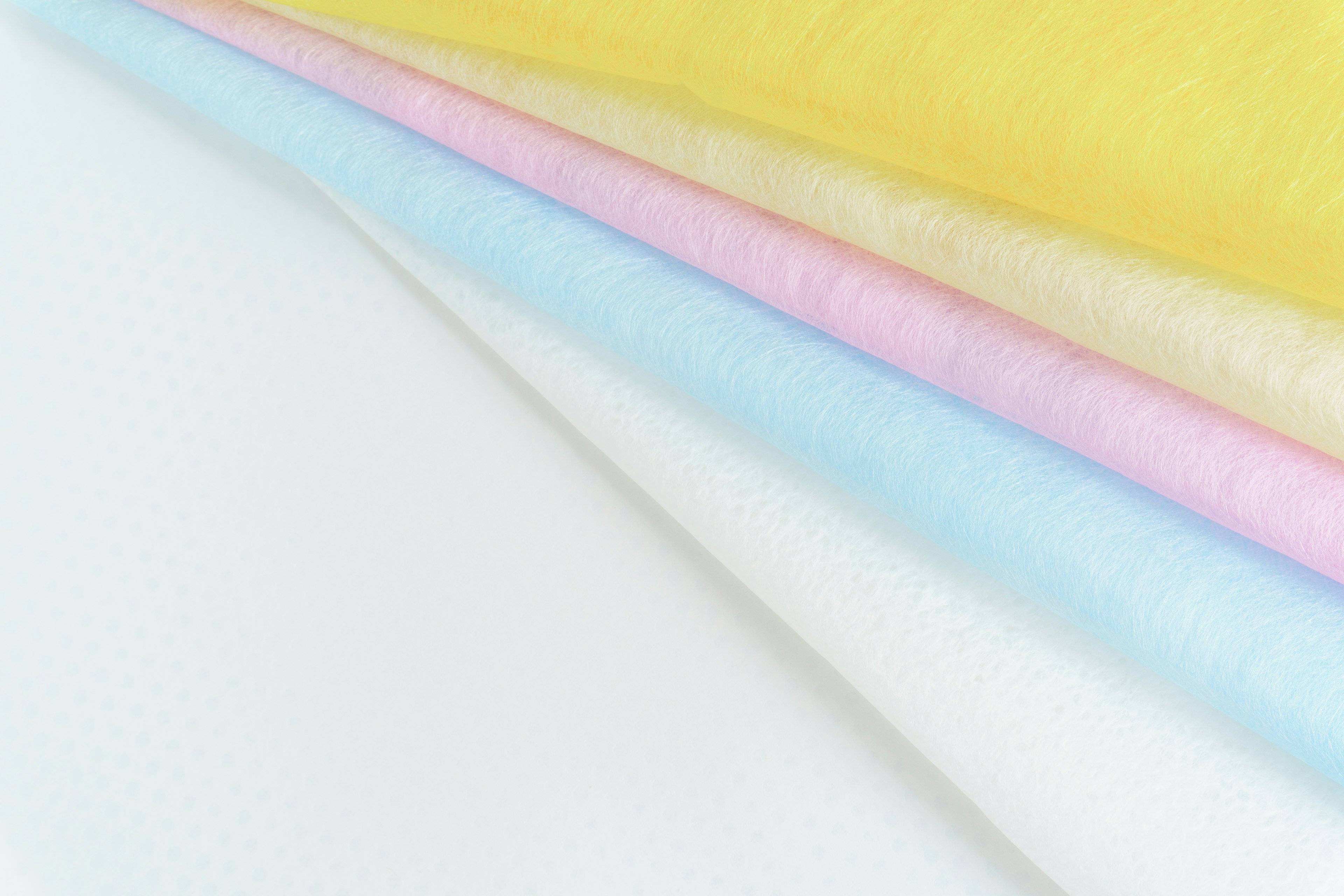 Capas de tela suave en blanco, amarillo, rosa y azul