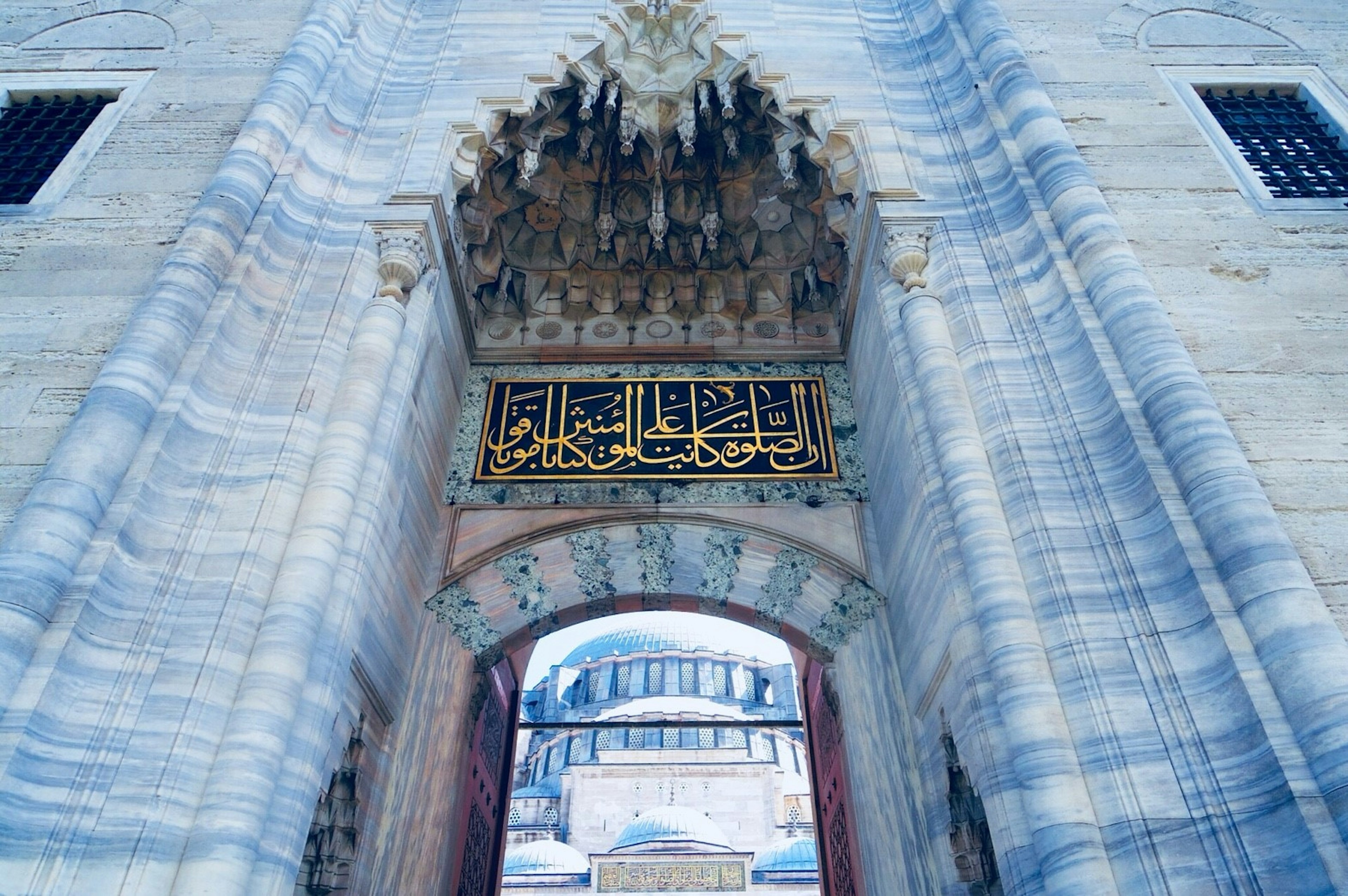 Image of a beautiful archway with golden decorations and historical building in the background