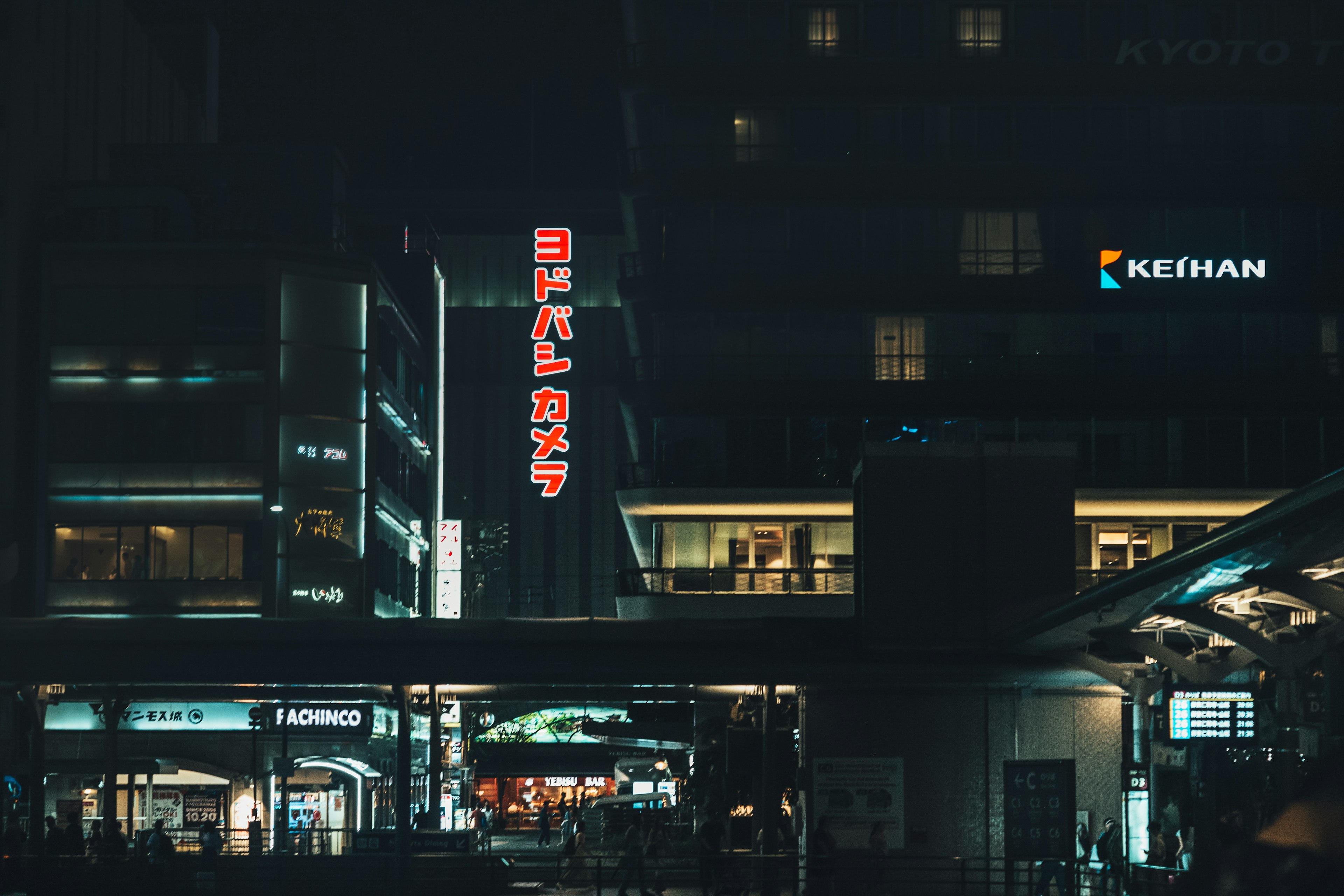 Edificio comercial con letreros de neón en un paisaje urbano nocturno