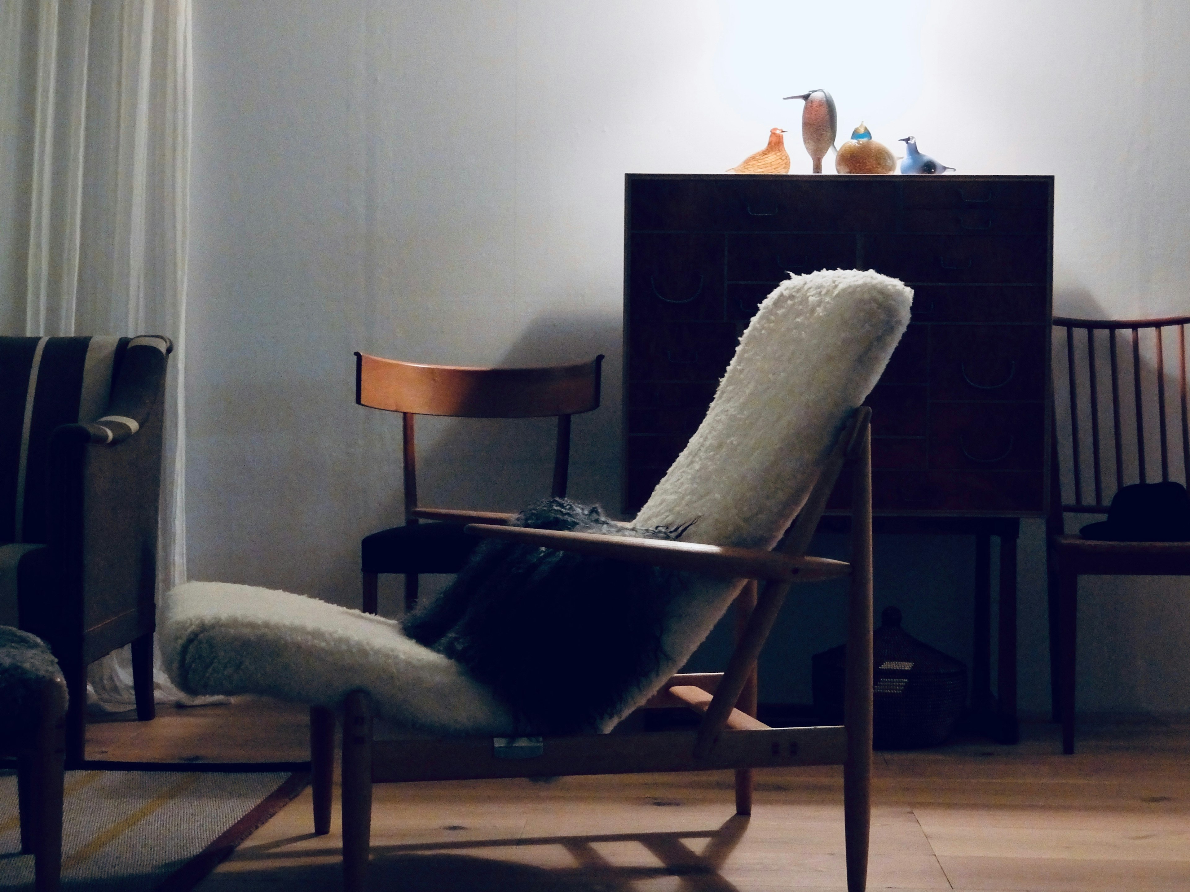 Un interior acogedor con una silla de madera y una silla reclinable con tapicería suave