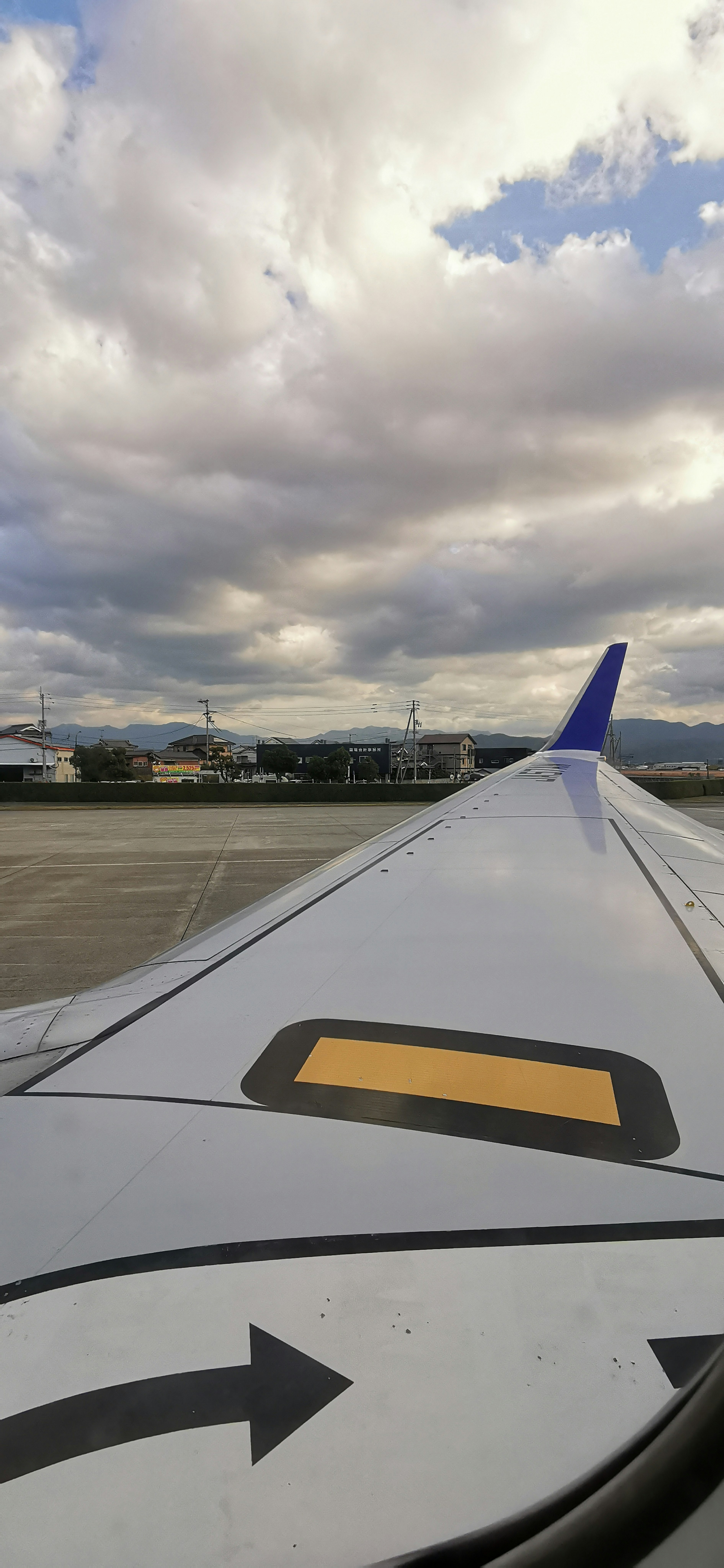 Vista del cielo nuvoloso e della pista dall'ala di un aereo