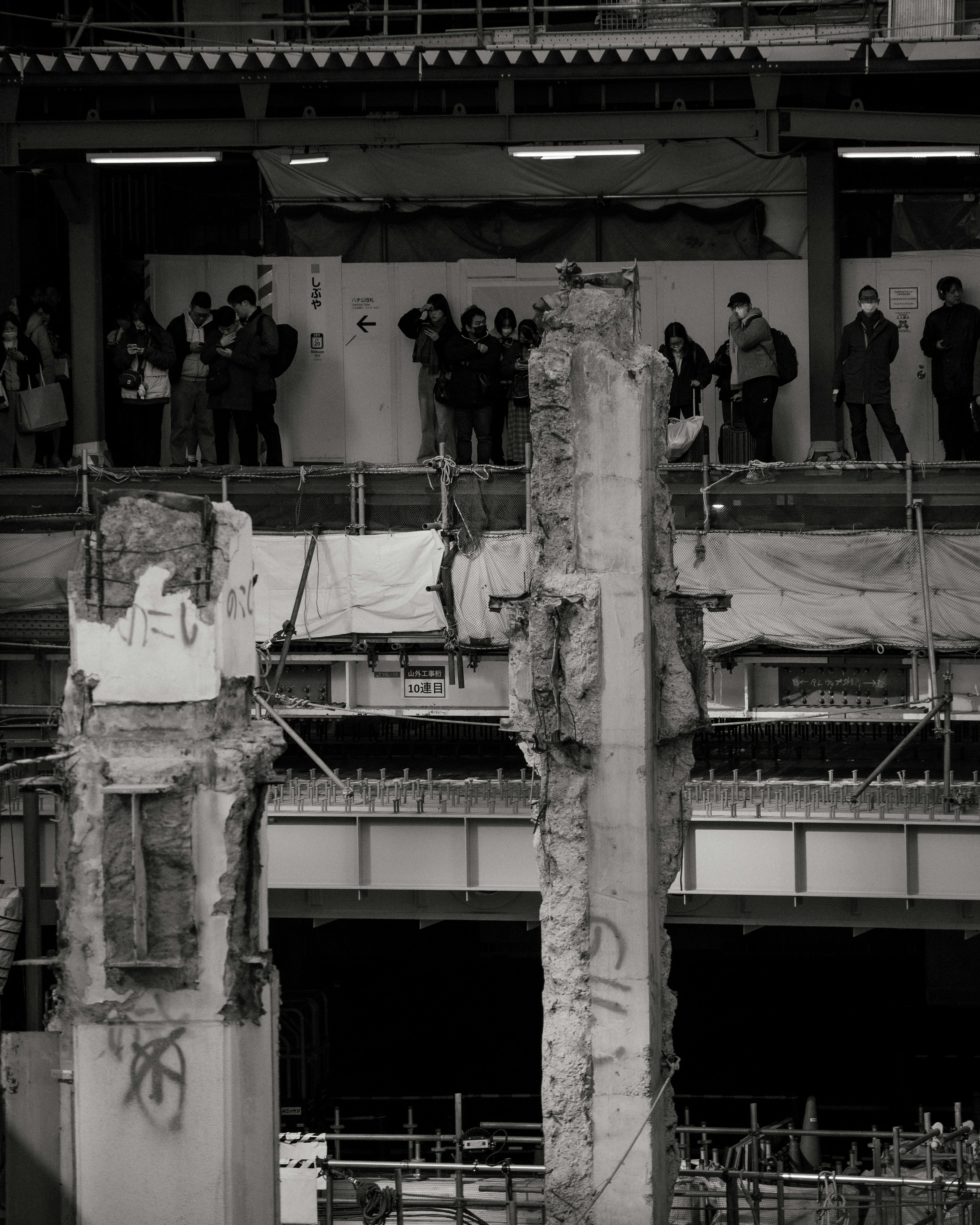 Photo en noir et blanc d'un chantier avec des personnes rassemblées en arrière-plan