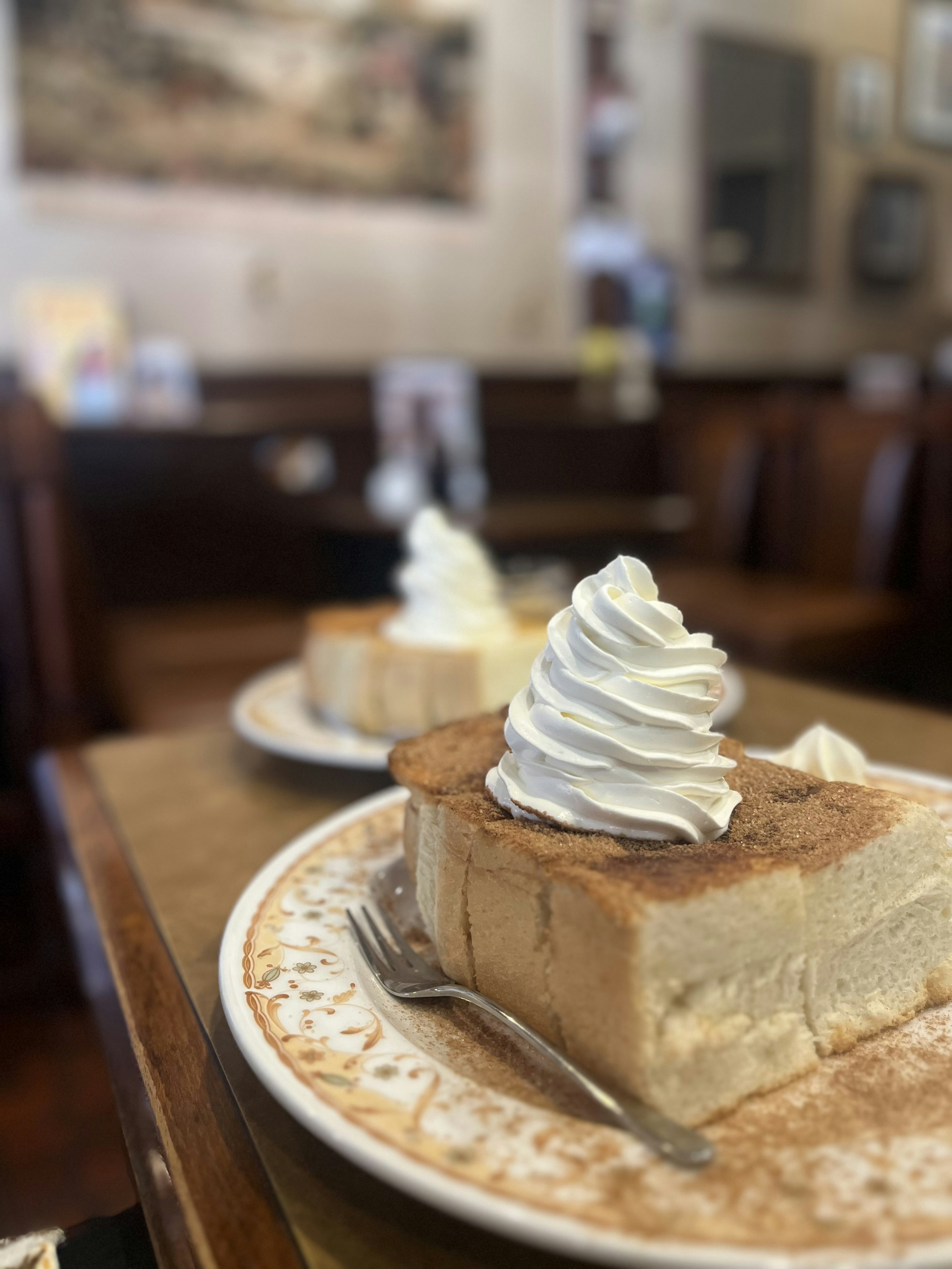 Una rebanada de postre cubierta con crema batida en un plato