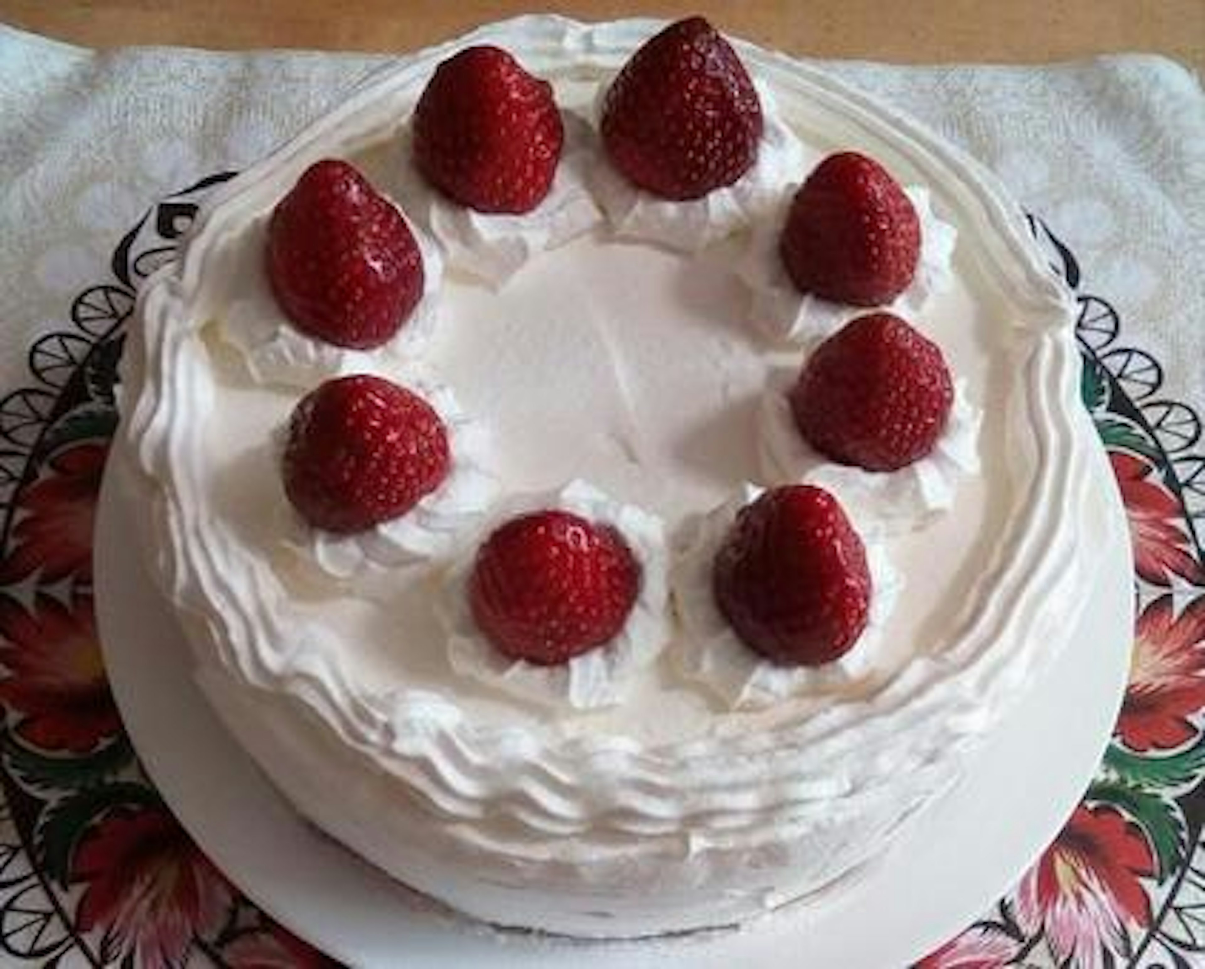 Cake topped with strawberries and whipped cream