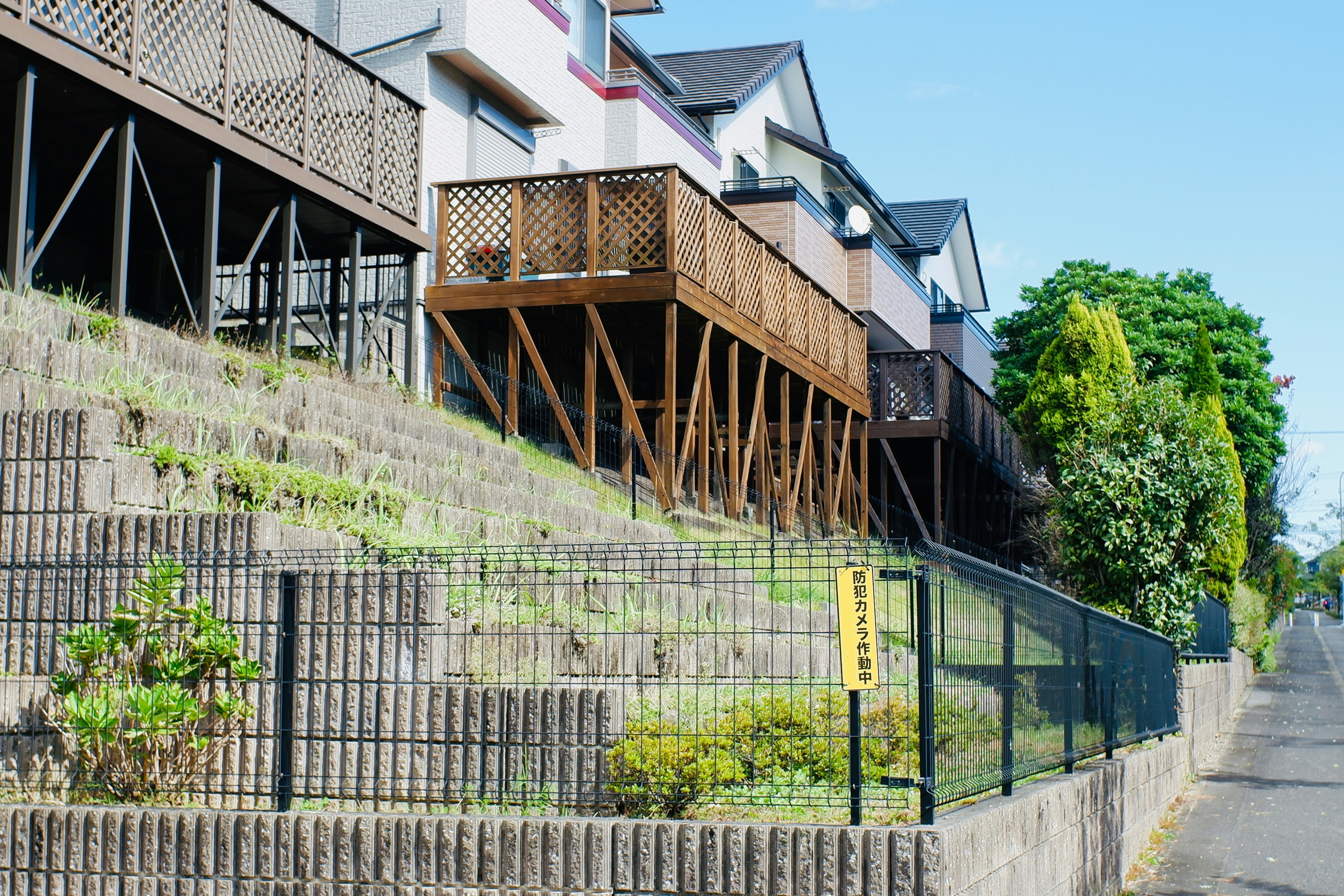 Houses on a slope with wooden balconies and greenery