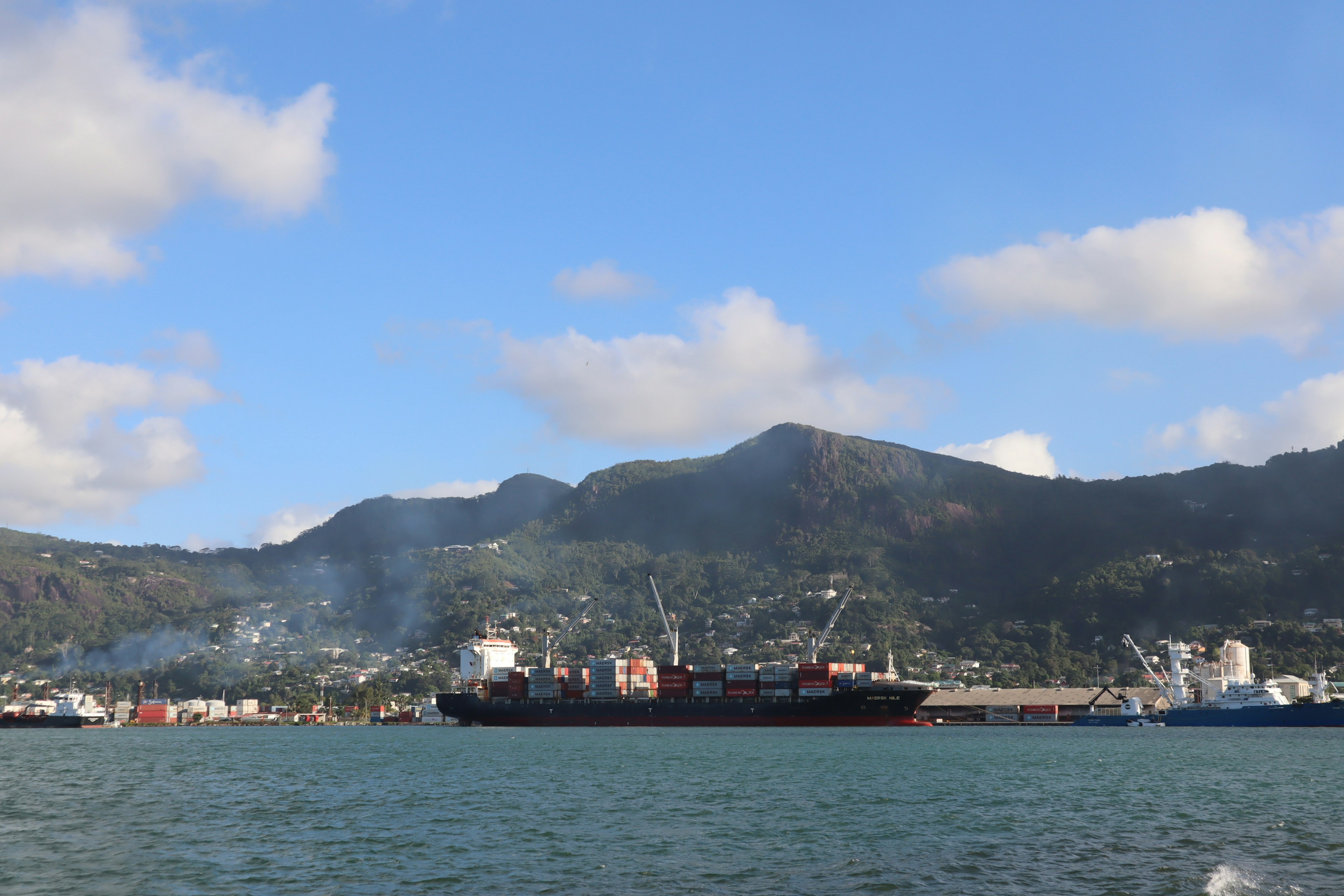 Cargo ship docked at the port with a blue sky backdrop