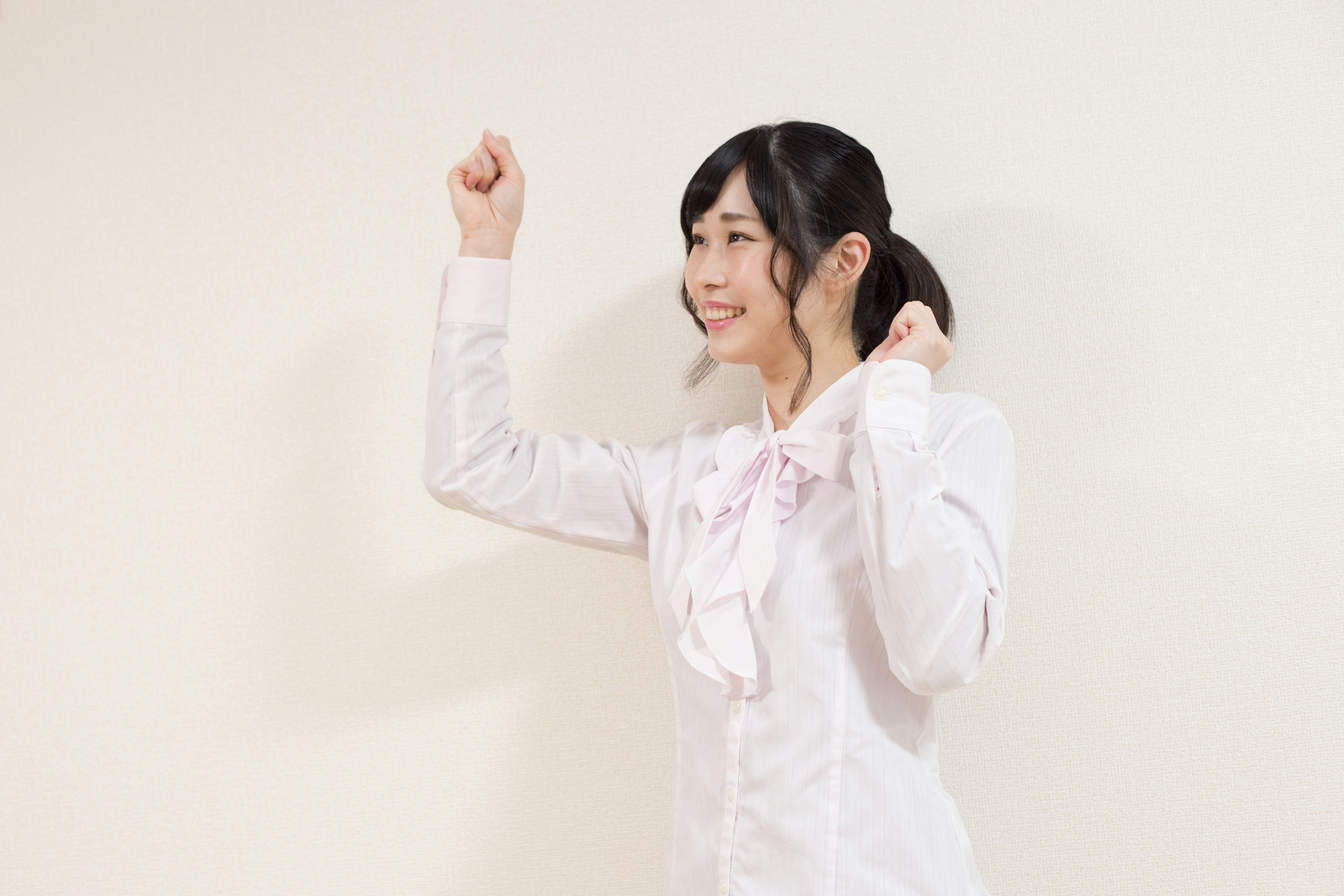 A woman in a white shirt showing a joyful pose