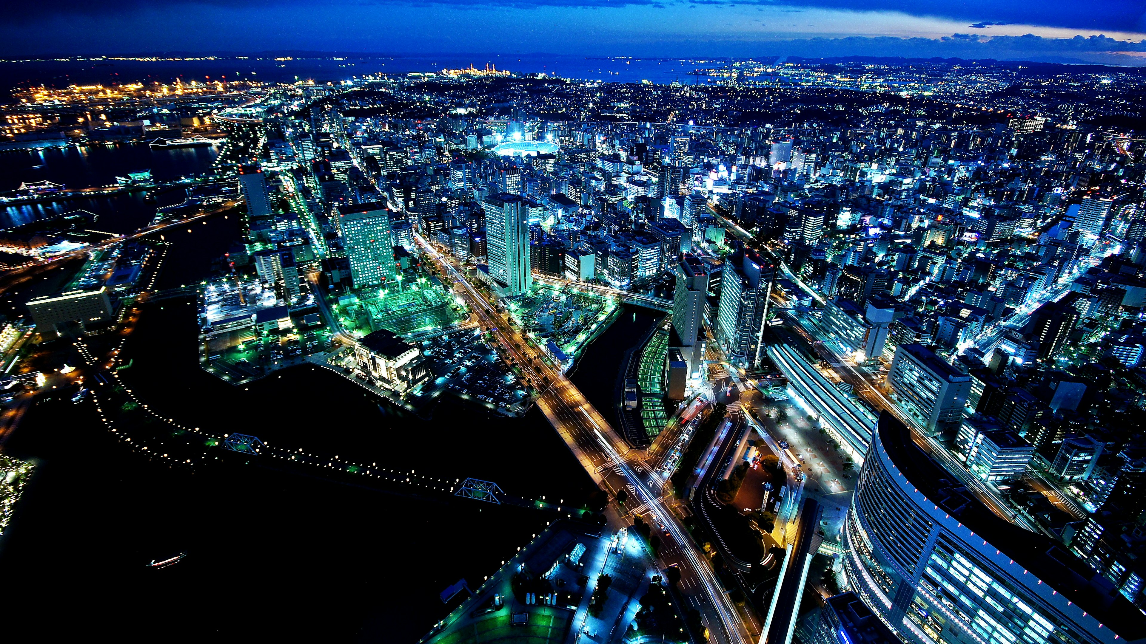 Aerial view of a city at night featuring skyscrapers and a river