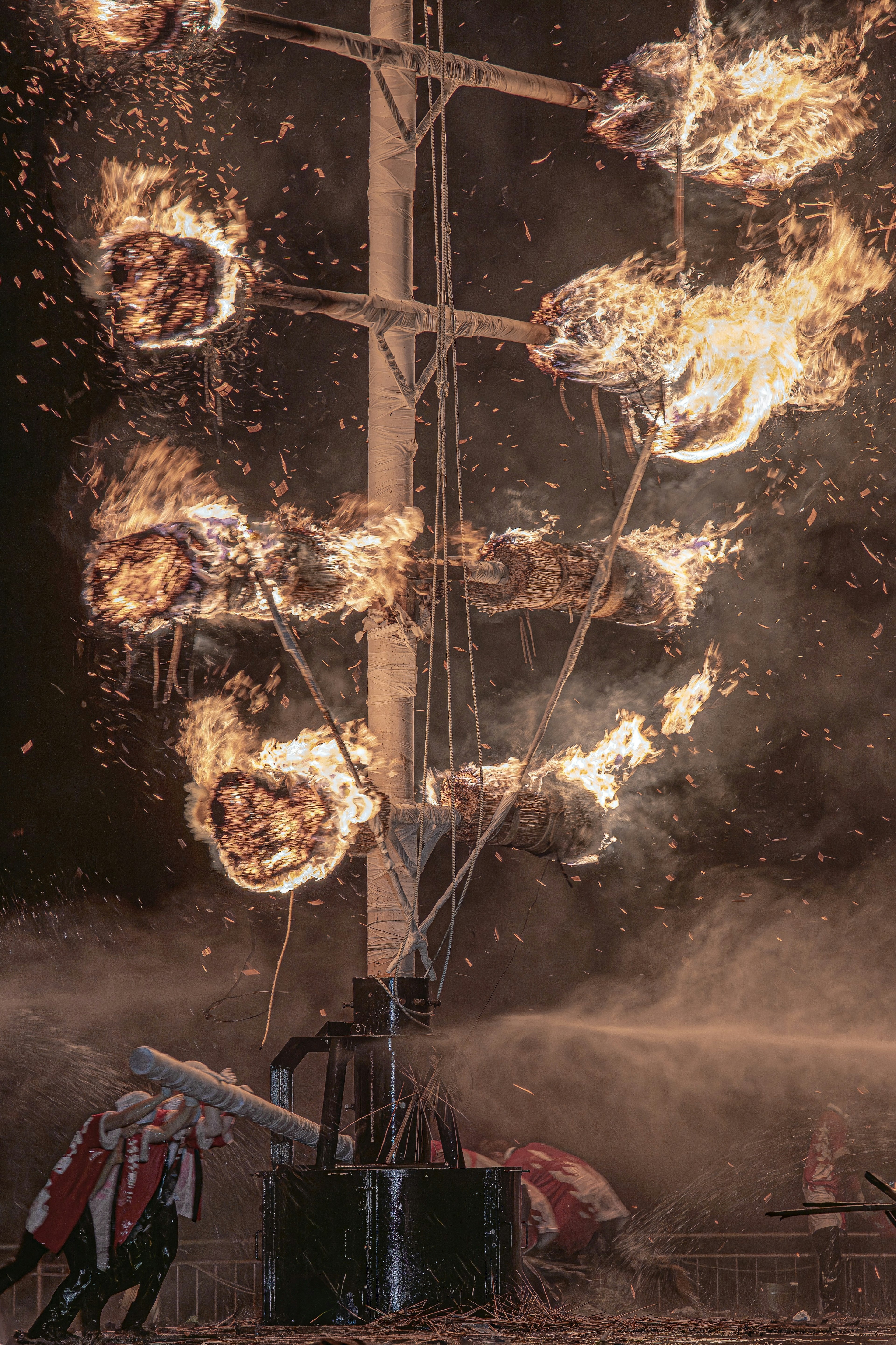 A burning mast surrounded by sparks and flames