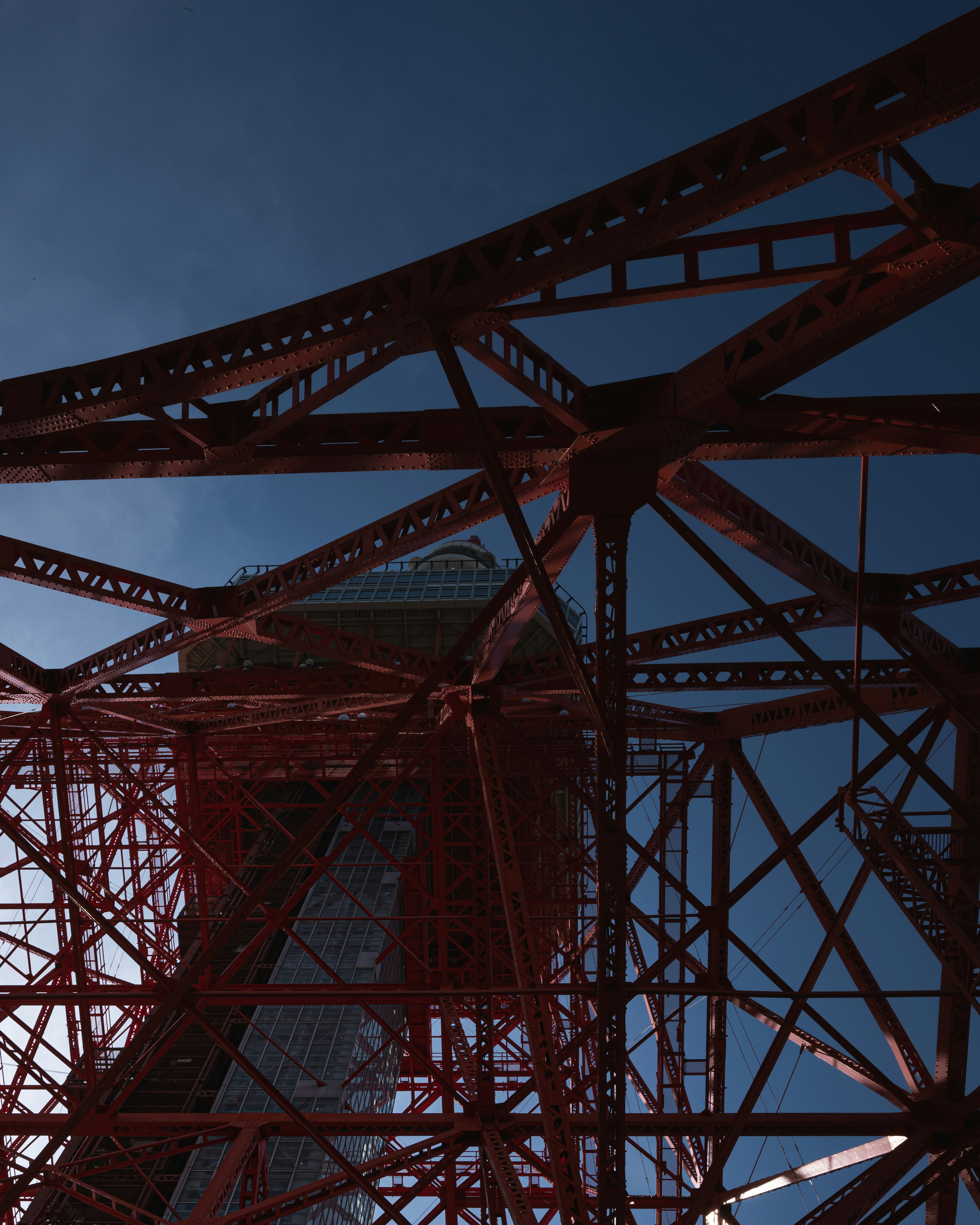 Pandangan ke atas struktur Menara Tokyo dengan balok baja merah yang mencolok