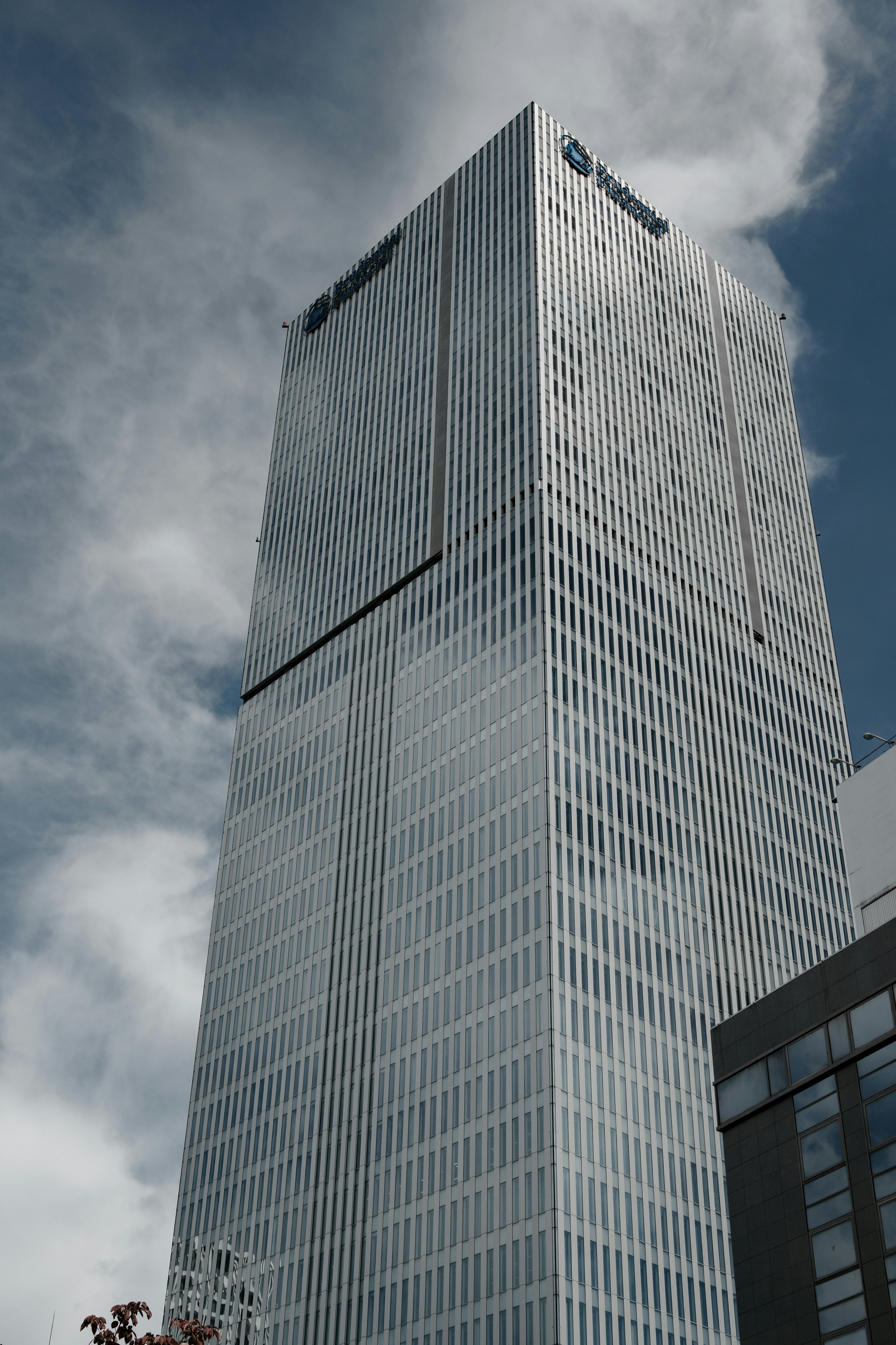 Tampilan dekat gedung pencakar langit di bawah langit biru dengan arsitektur modern