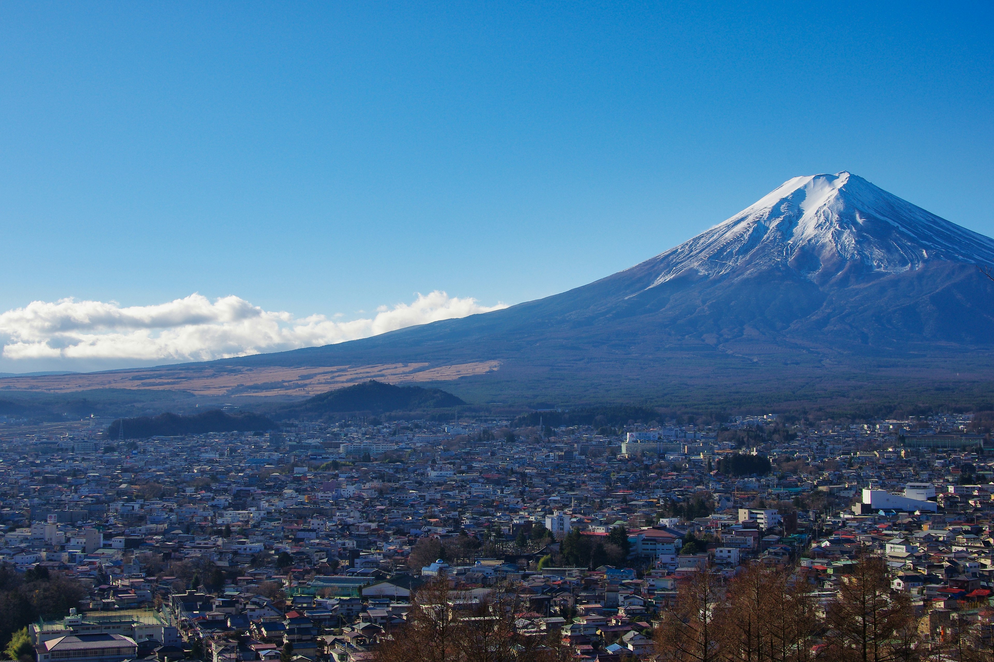 Impresionante vista del monte Fuji con un cielo azul claro y una ciudad que se extiende abajo