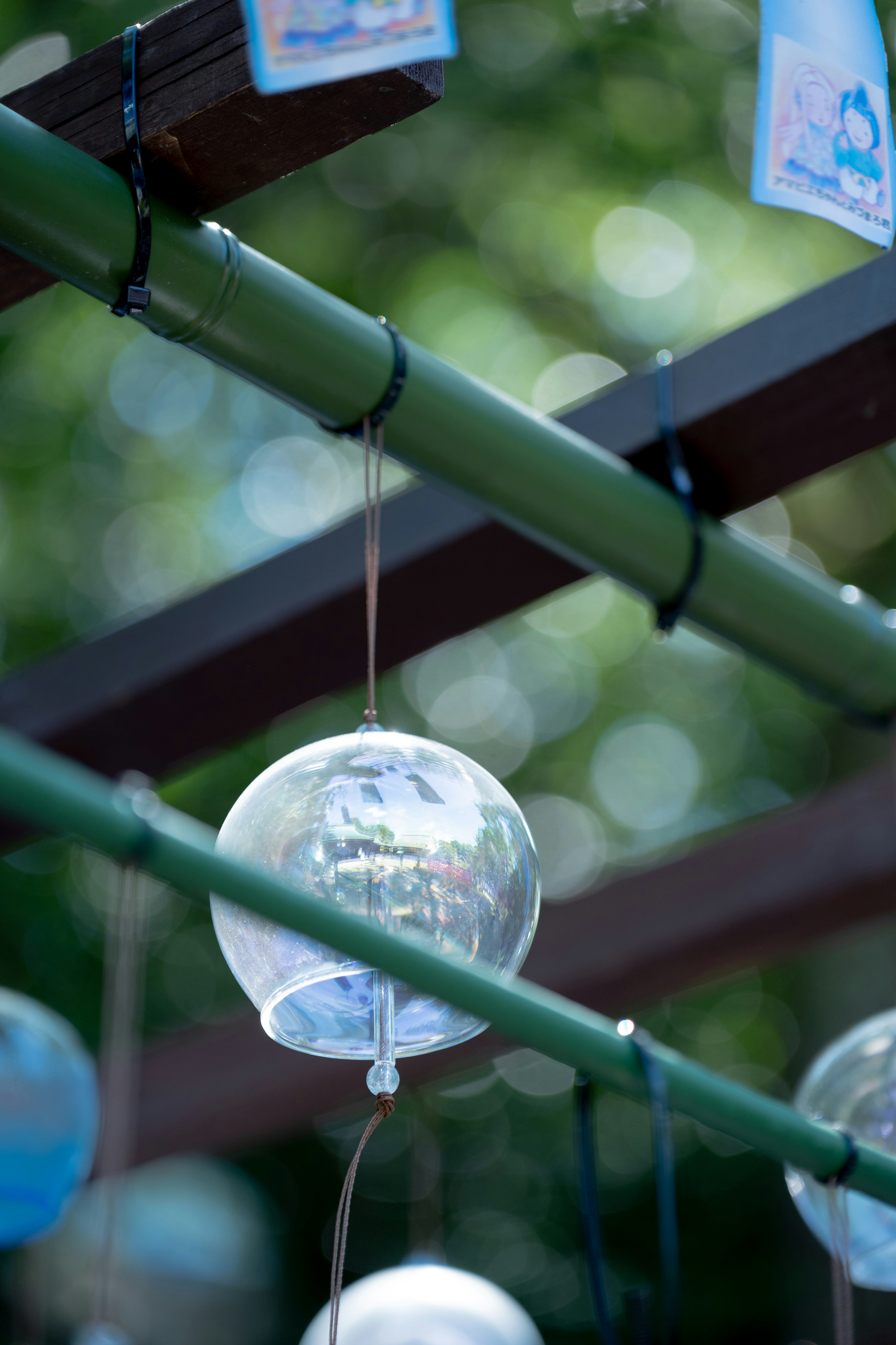 Blue wind chimes hanging from a bamboo structure