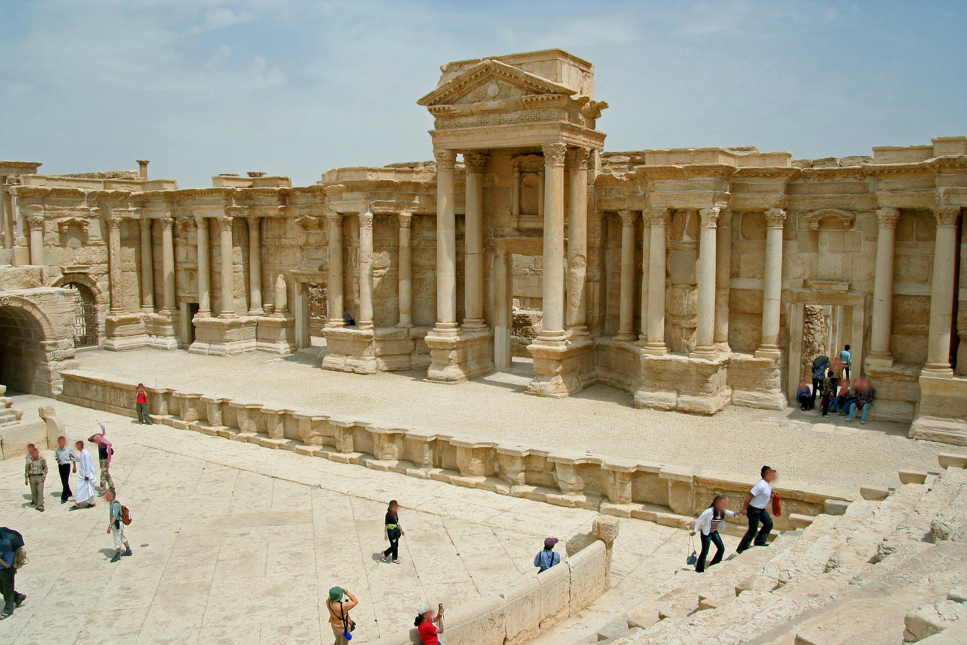 Rovine antiche di Palmira con grandi edifici e colonne con visitatori che esplorano