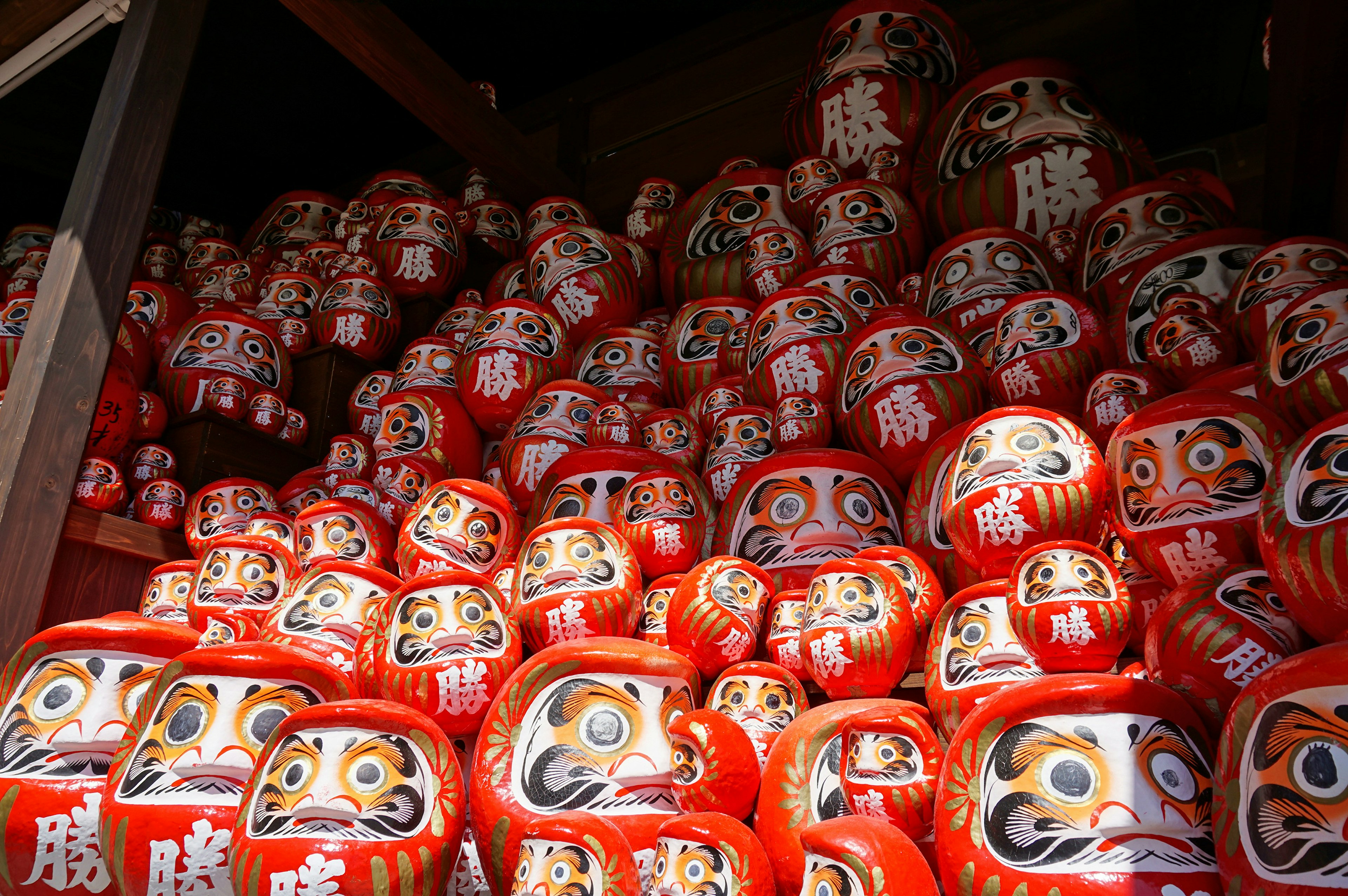 A multitude of red Daruma dolls stacked together