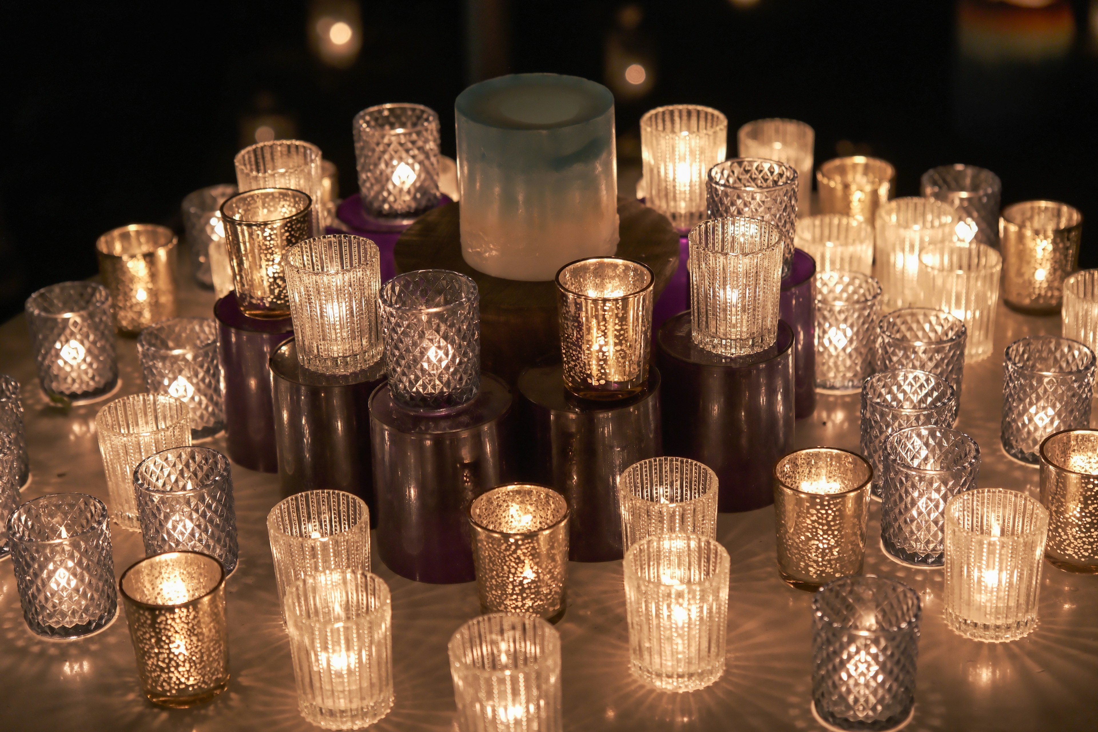 Una disposición circular de varios portacandelas brillando con luz de vela