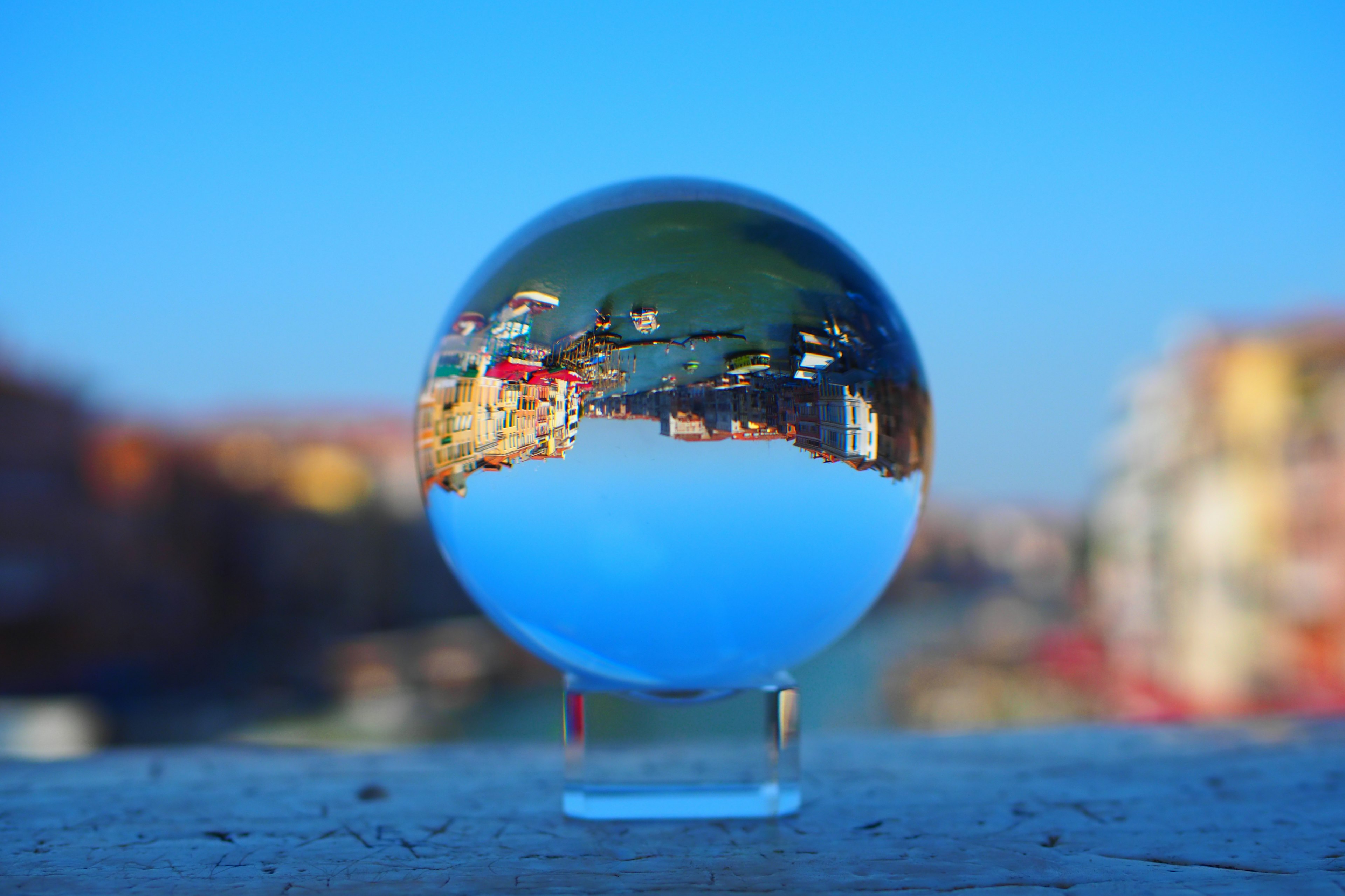 A crystal ball reflecting a cityscape with blue sky