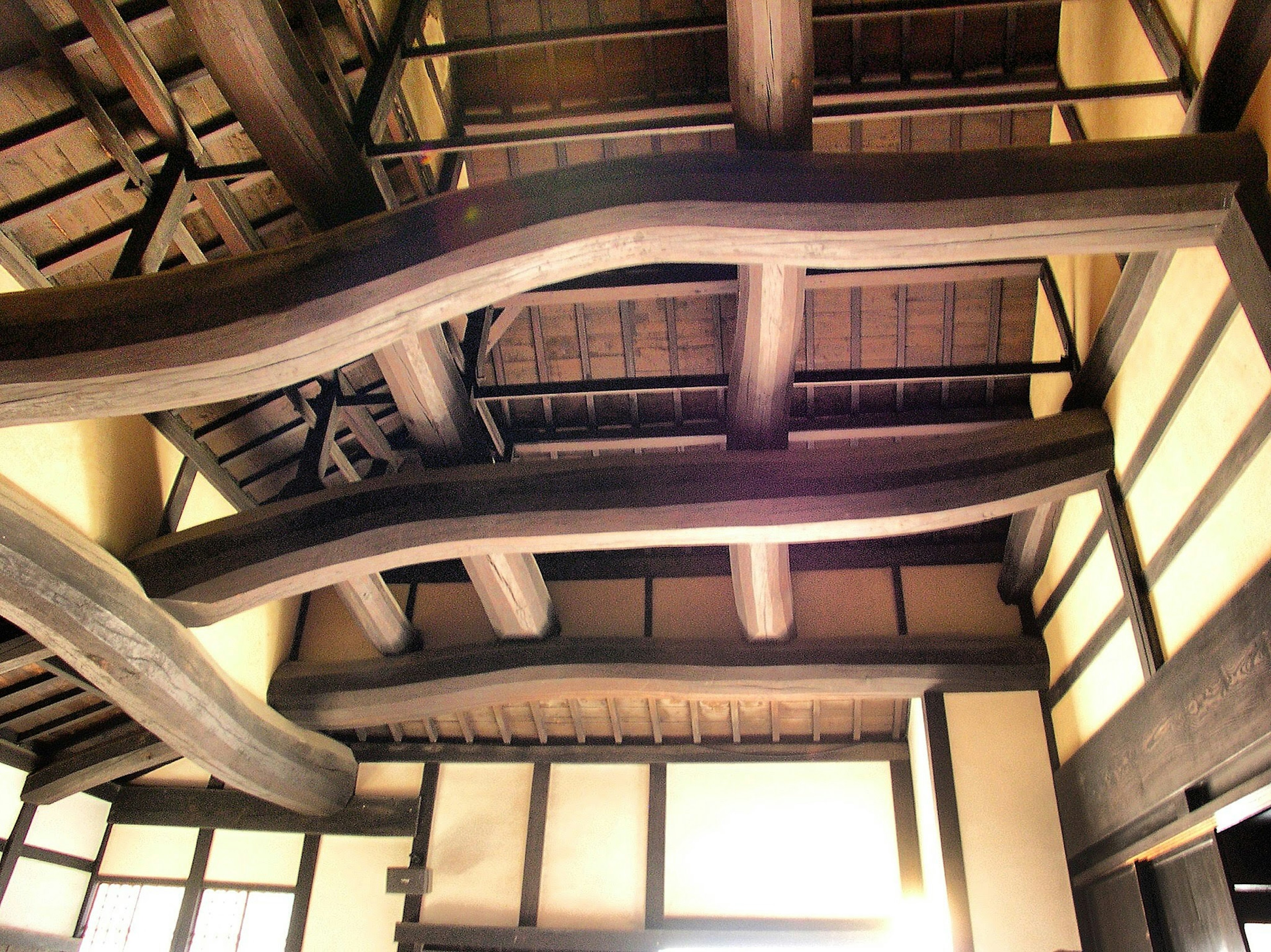 Vista interior de un edificio japonés tradicional con vigas de madera curvas únicas