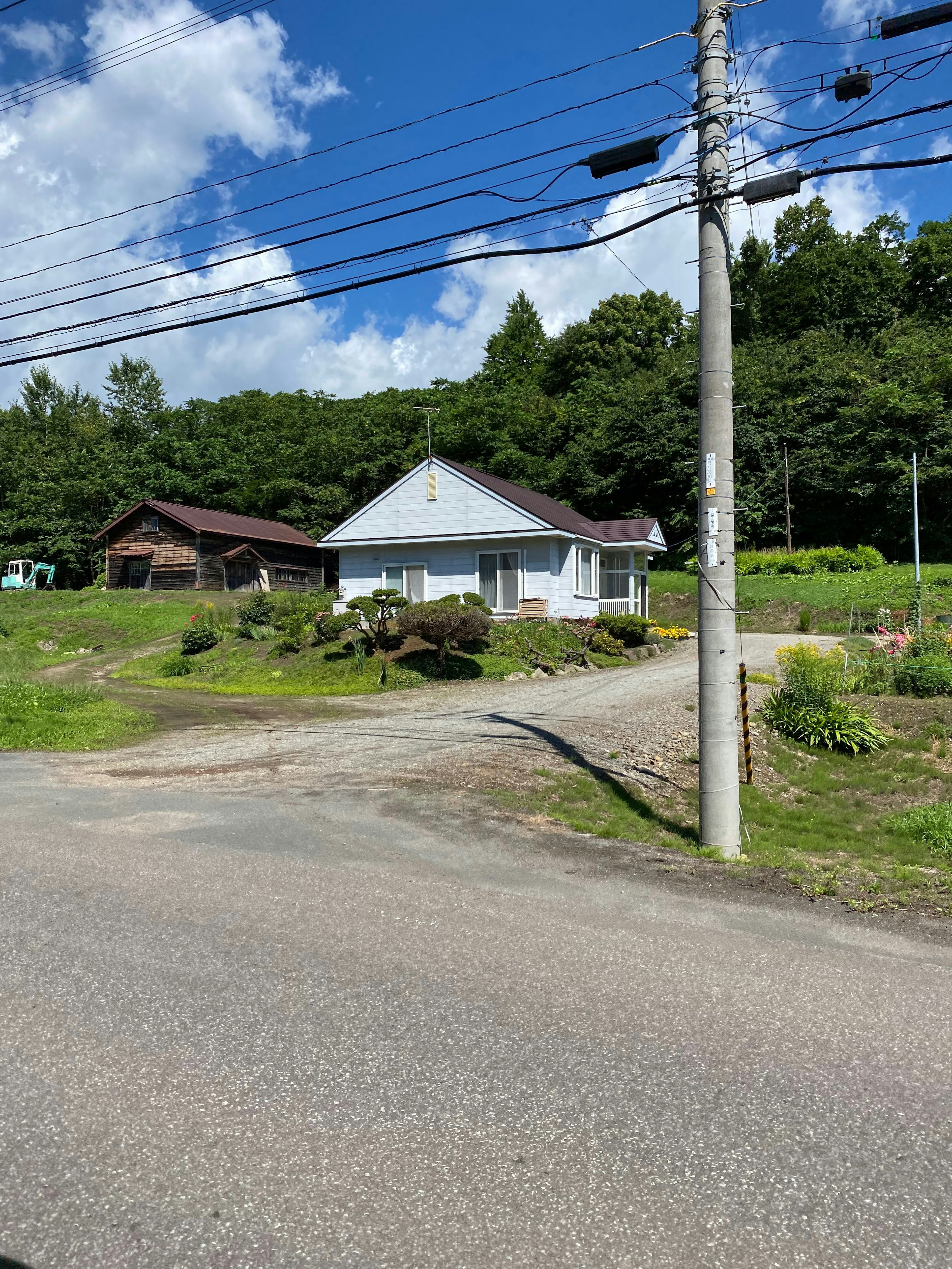 Rumah putih dengan latar belakang bukit hijau