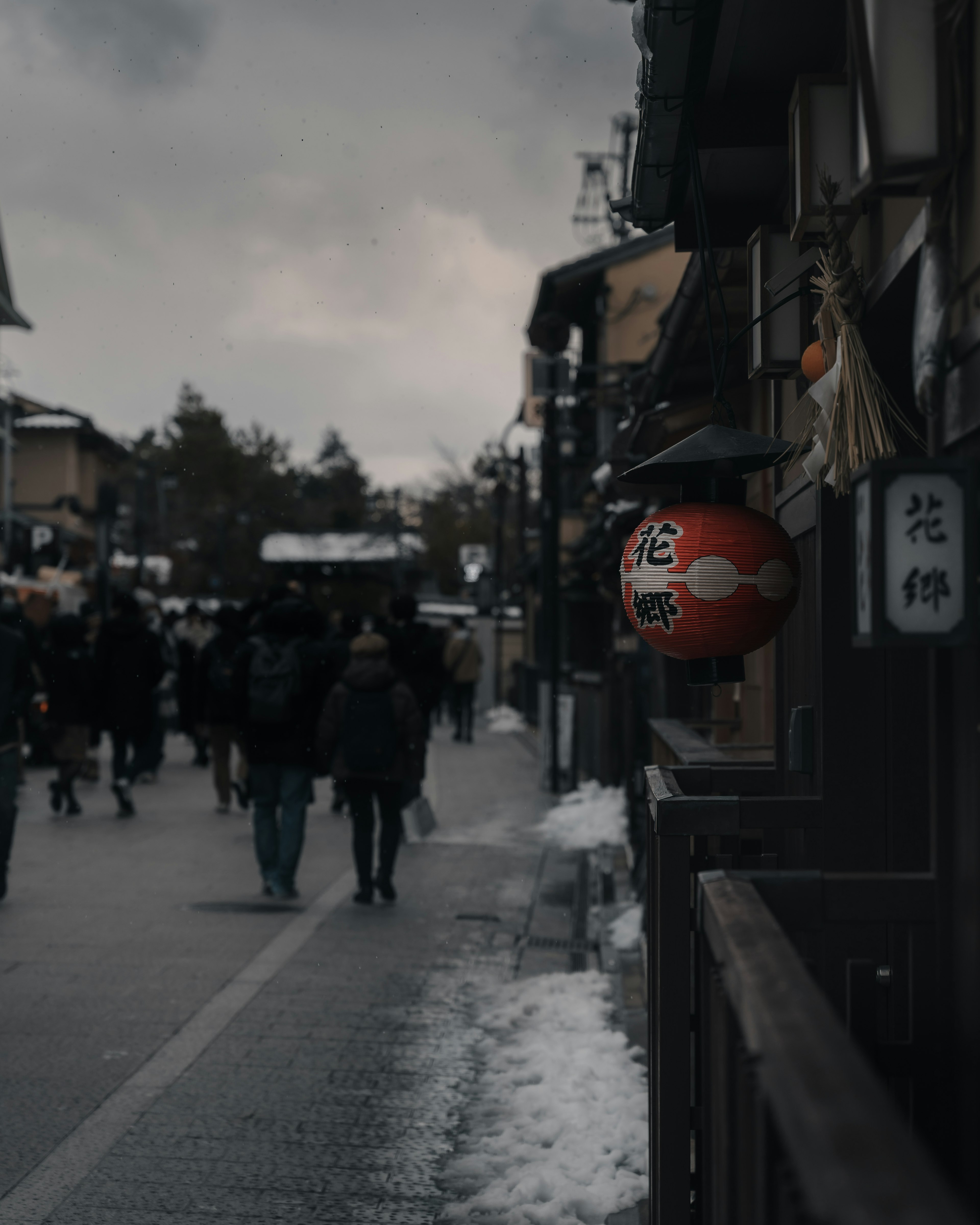 Escena de calle japonesa con una linterna roja y un camino nevado