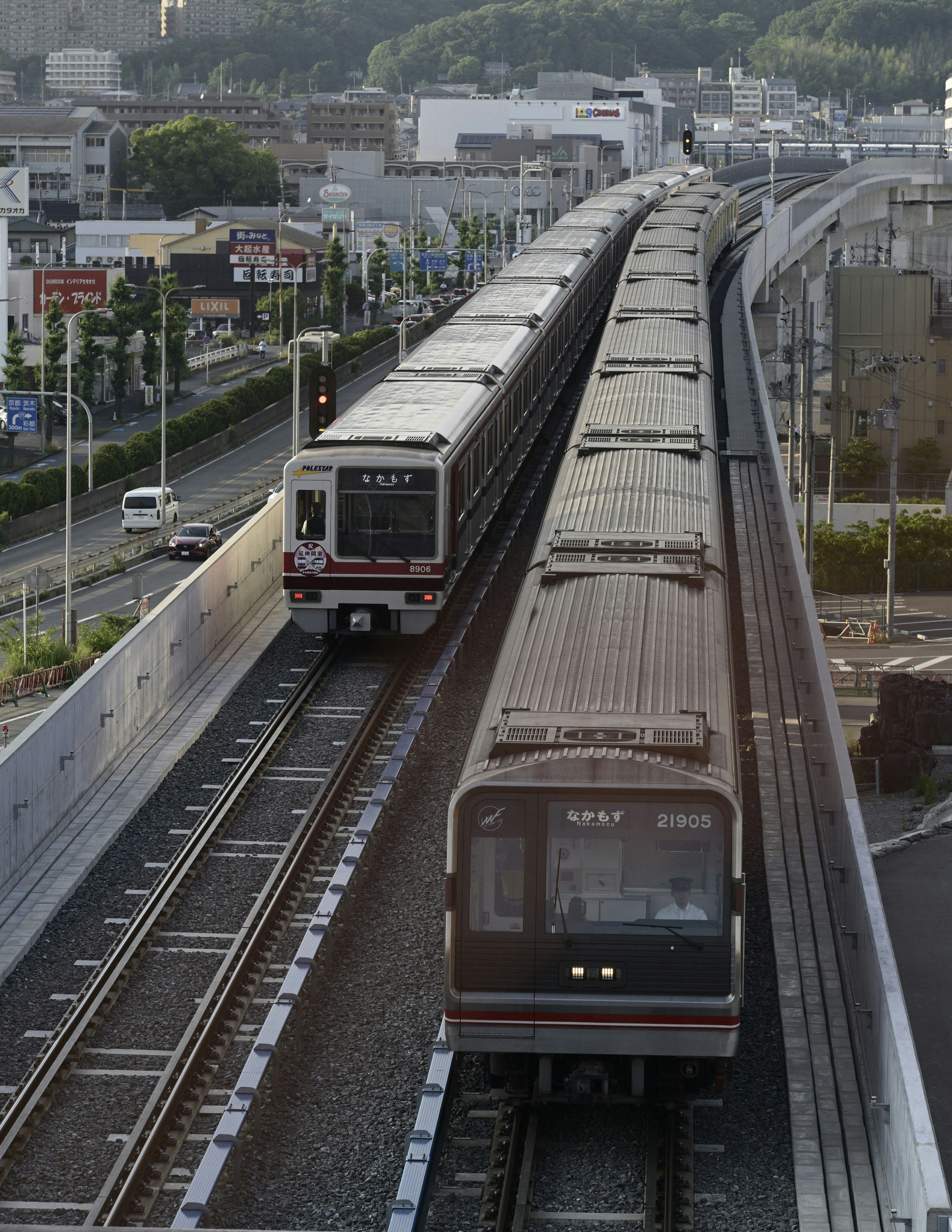 鉄道の線路に沿って走る2つの電車が見える都市の風景