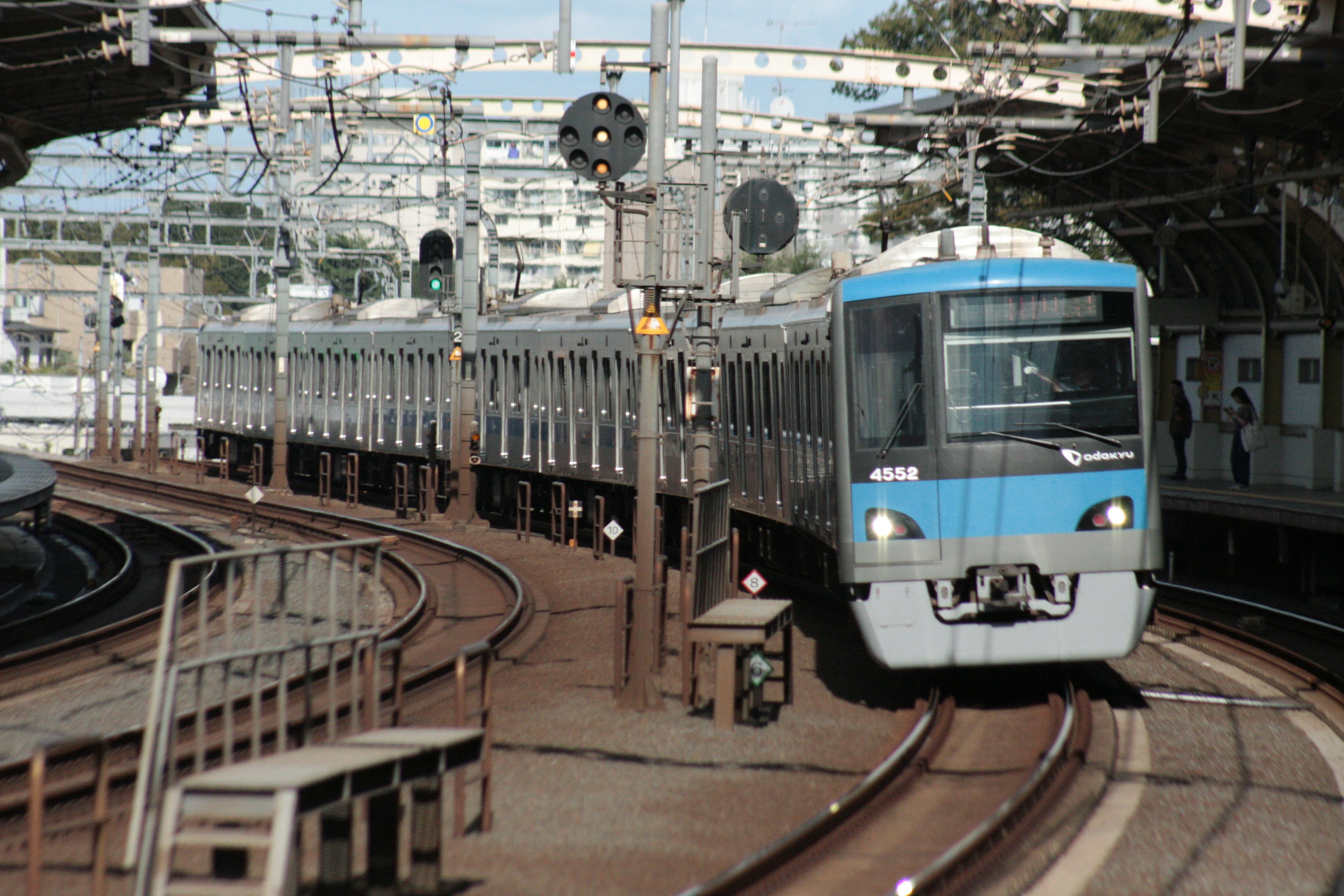 Blue train navigating a curve at a railway station