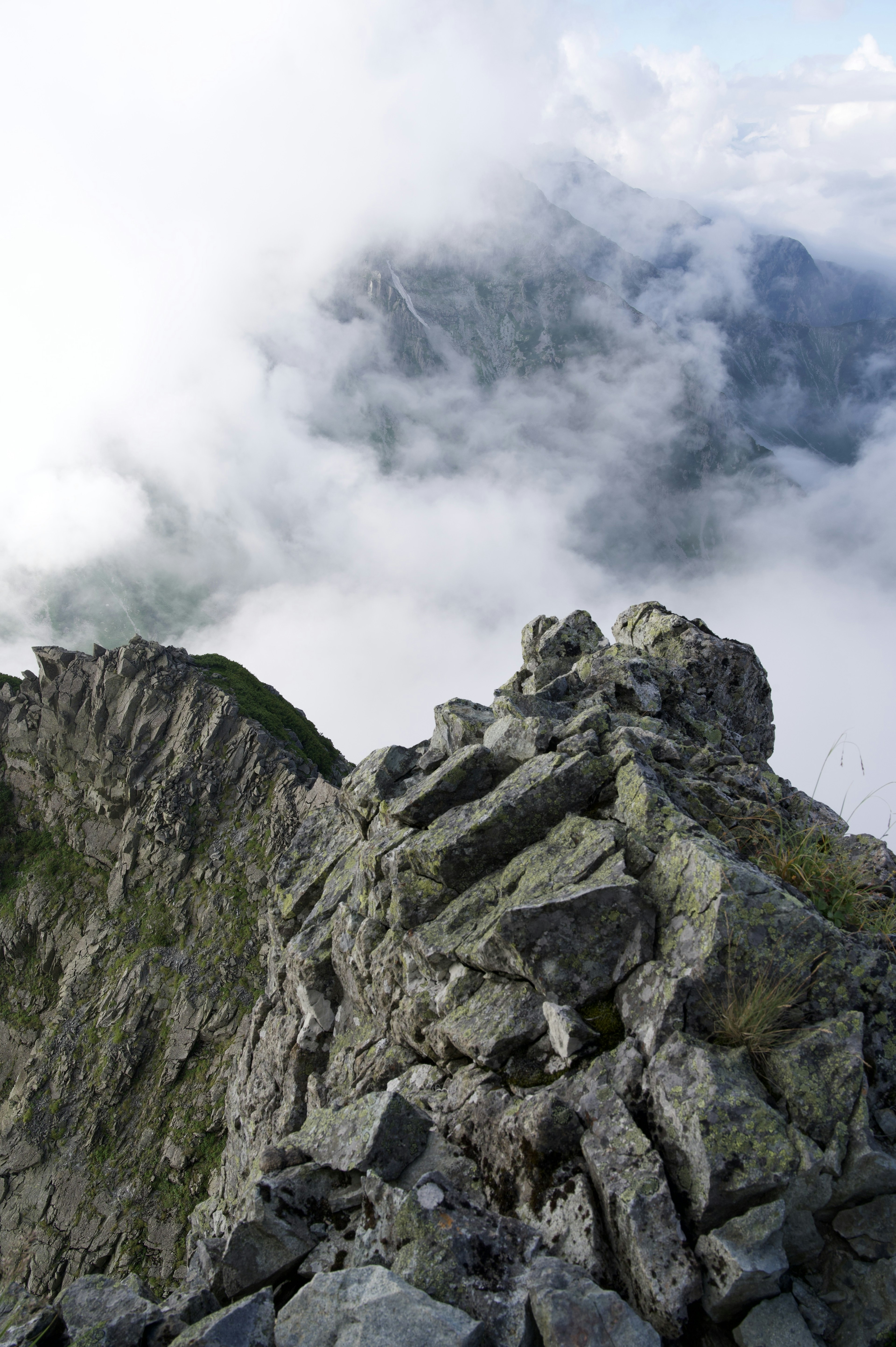 Vista panoramica dalla cima di una montagna rocciosa sopra le nuvole